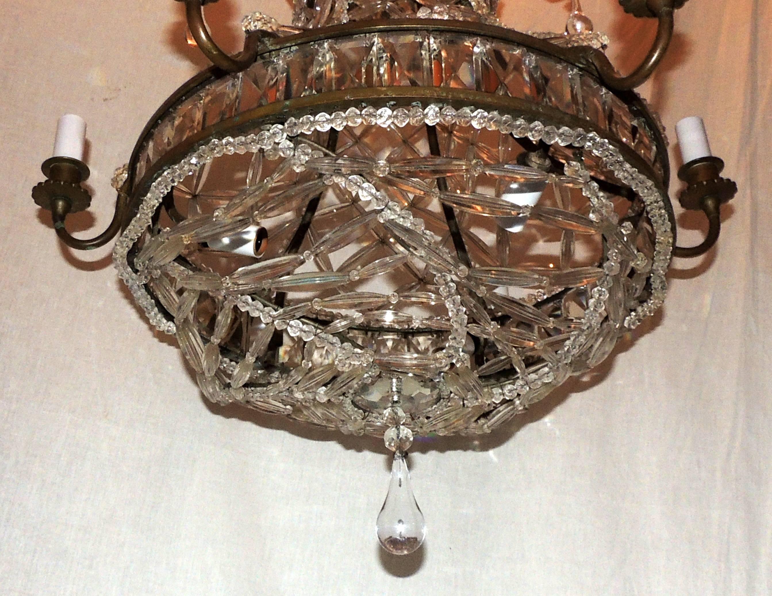 A wonderful French bronze and crystal lattice form beaded basket chandelier with tear drop crystals.
This beautiful fixture has six lights around the outside band and also has three internal lights.
Measures: 22