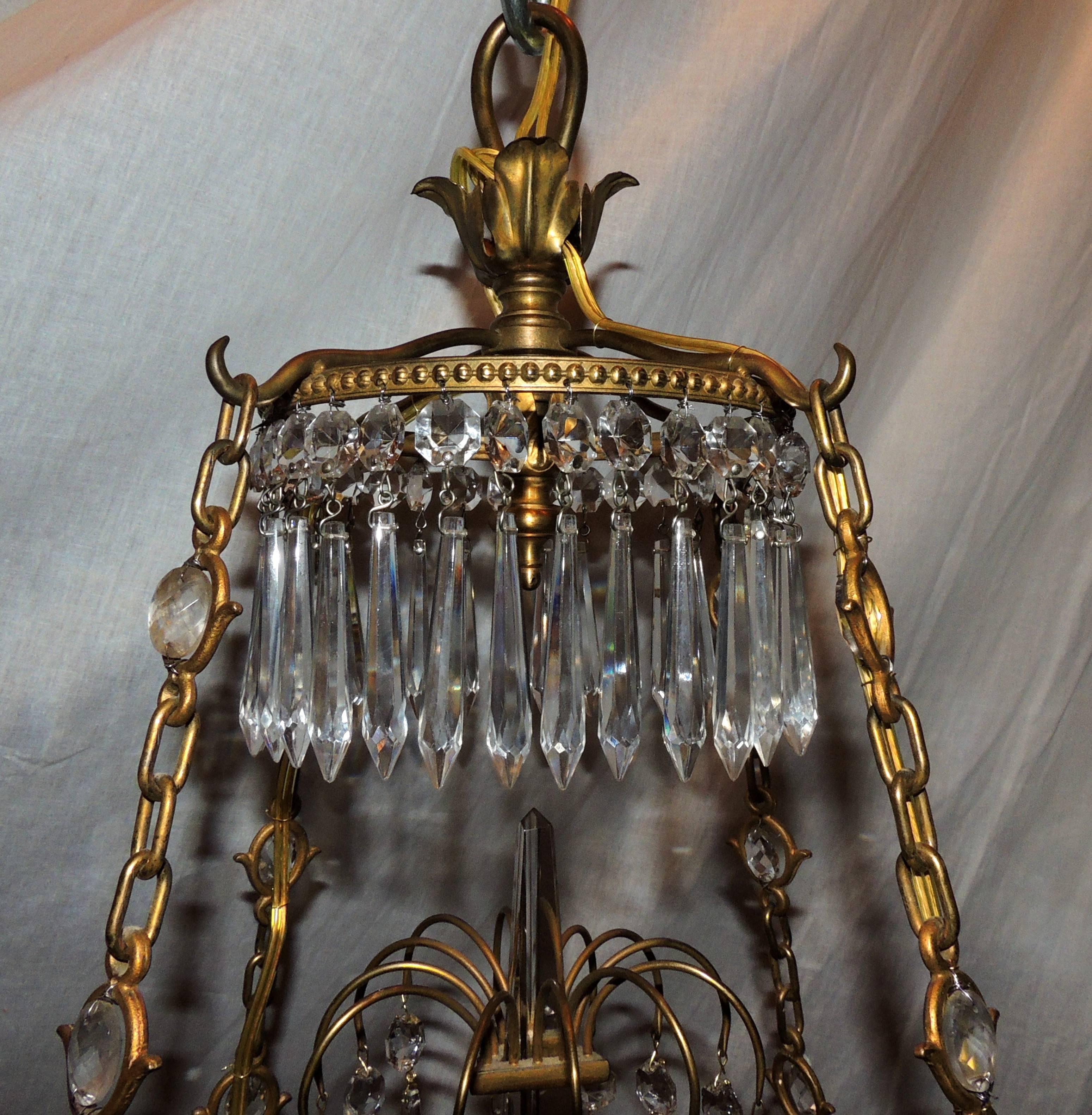 An exceptional French Regency doré bronze and cut crystal centre bowl Empire or Baltic eight-arm chandelier dressed with cut crystals bobeches and surrounding a ribbed gallery rim draping with crystals and finished in the centre with a diamond cut