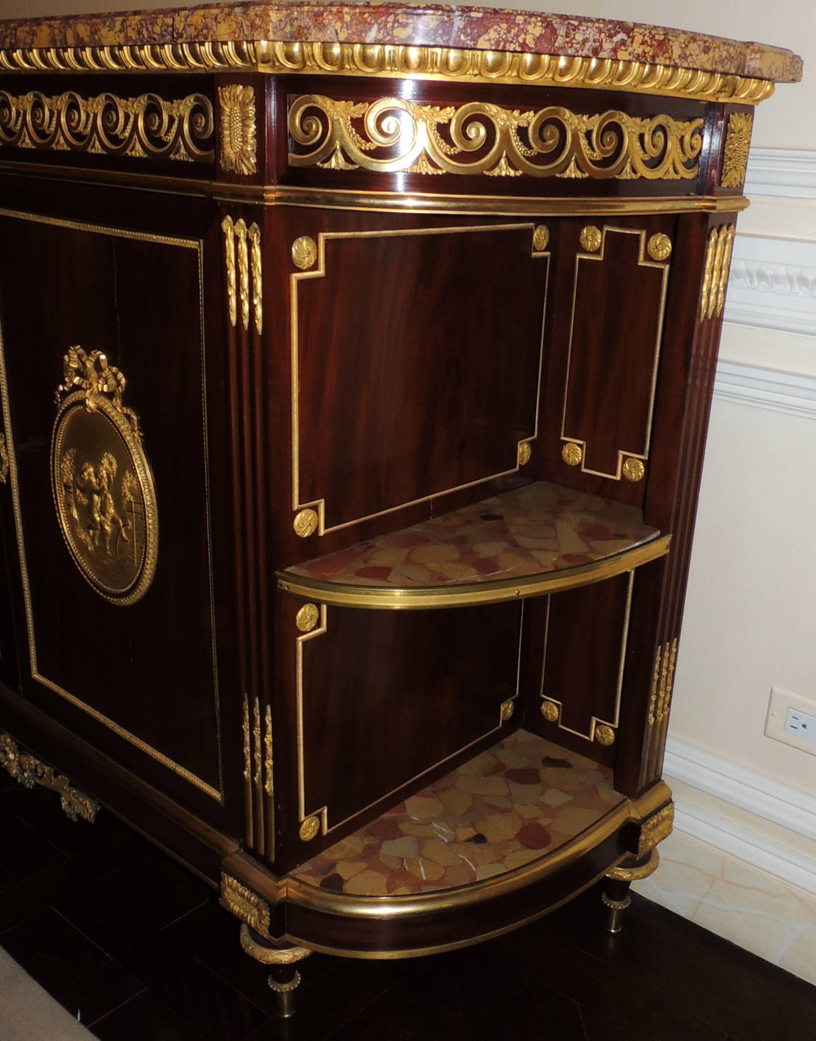 A very fine Louis xvi style gilt dore bronze oval cherub plaque ormolu mounted mahogany & marble top, demilune dessert commode / sideboard console in the manner of franc¸ois linke.