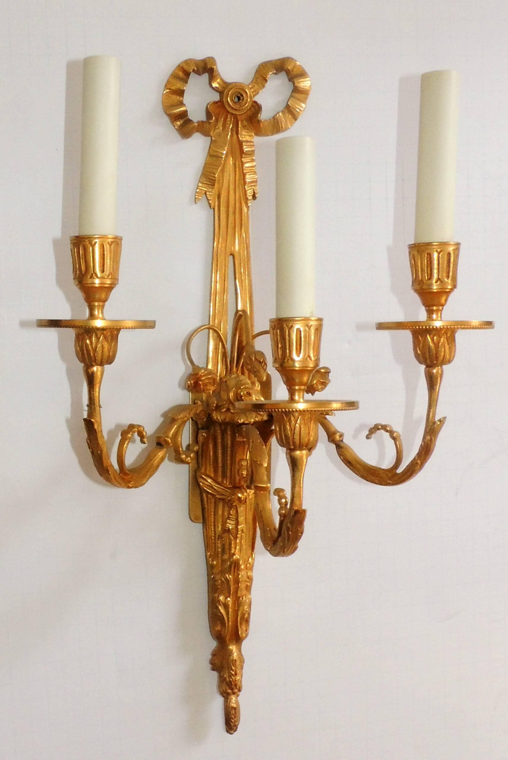 A wonderful regency style set of four French gilt doré bronze, bow top and flower spray three-light sconces wired and ready to enjoy.
Sold per pair.