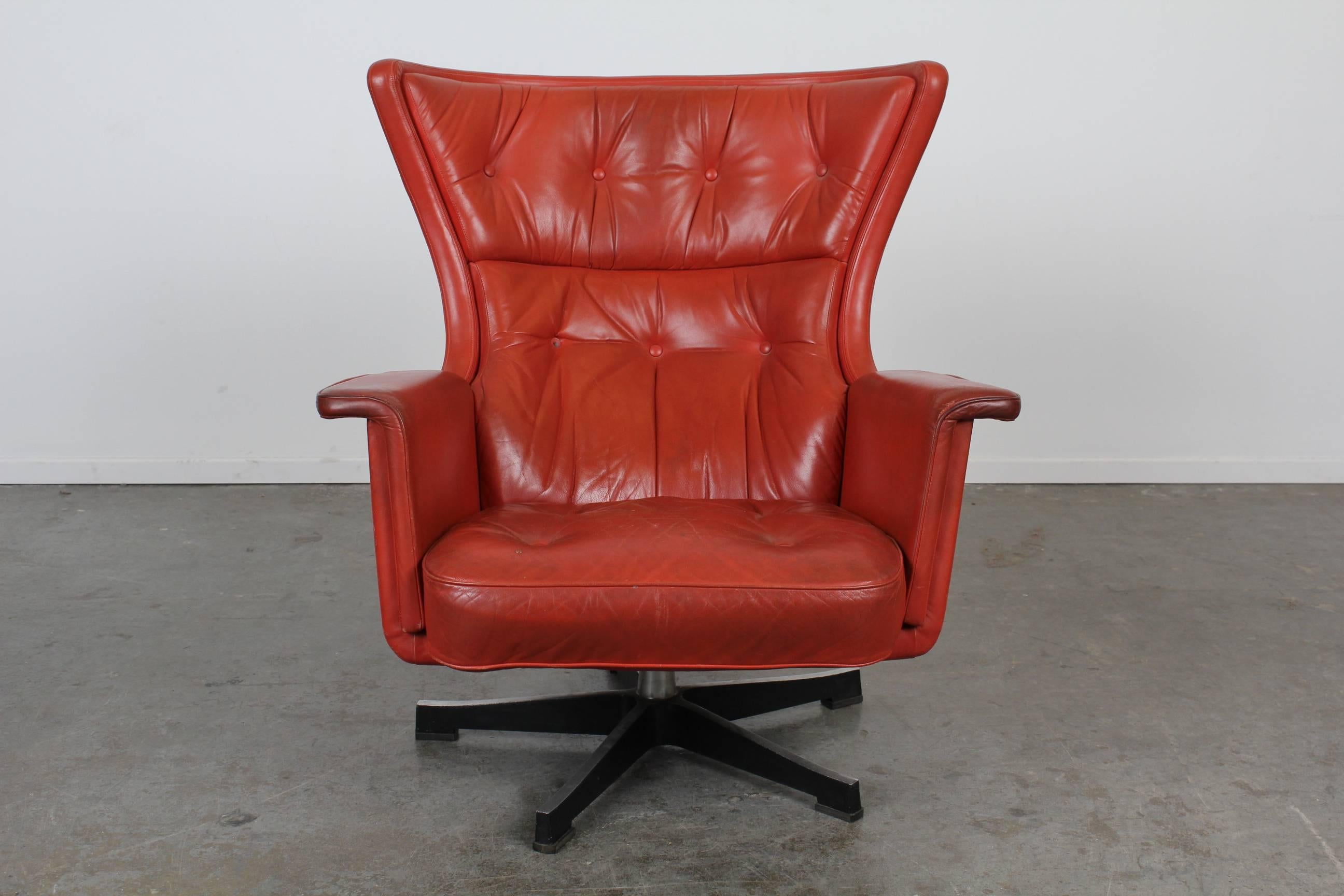 Vintage red leather swivel lounge chair with ottoman, designed by Karl Erik Ekselius. Matching pair available.
