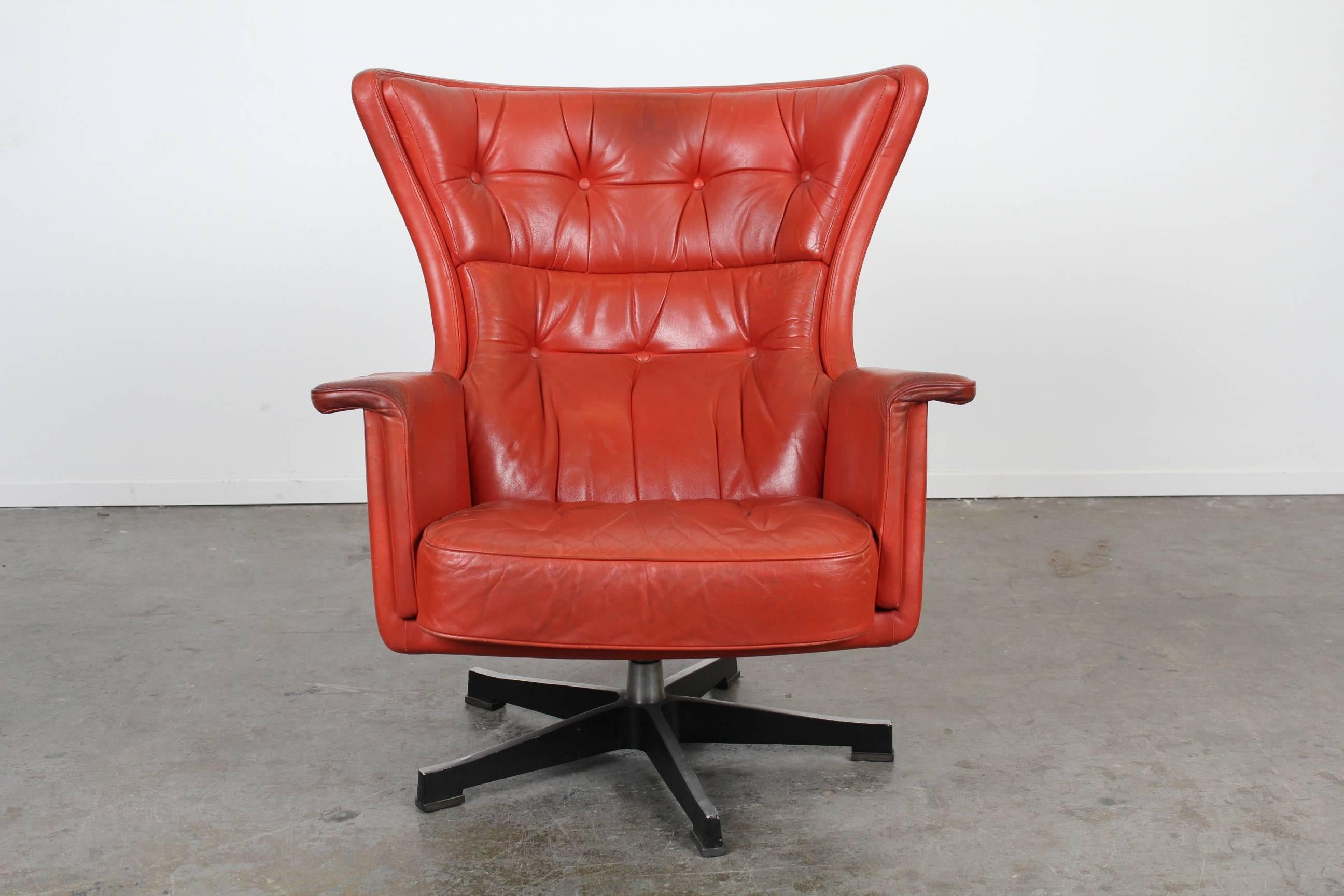 Vintage red leather swivel lounge chair with ottoman, designed by Karl Erik Ekselius. Matching pair available.