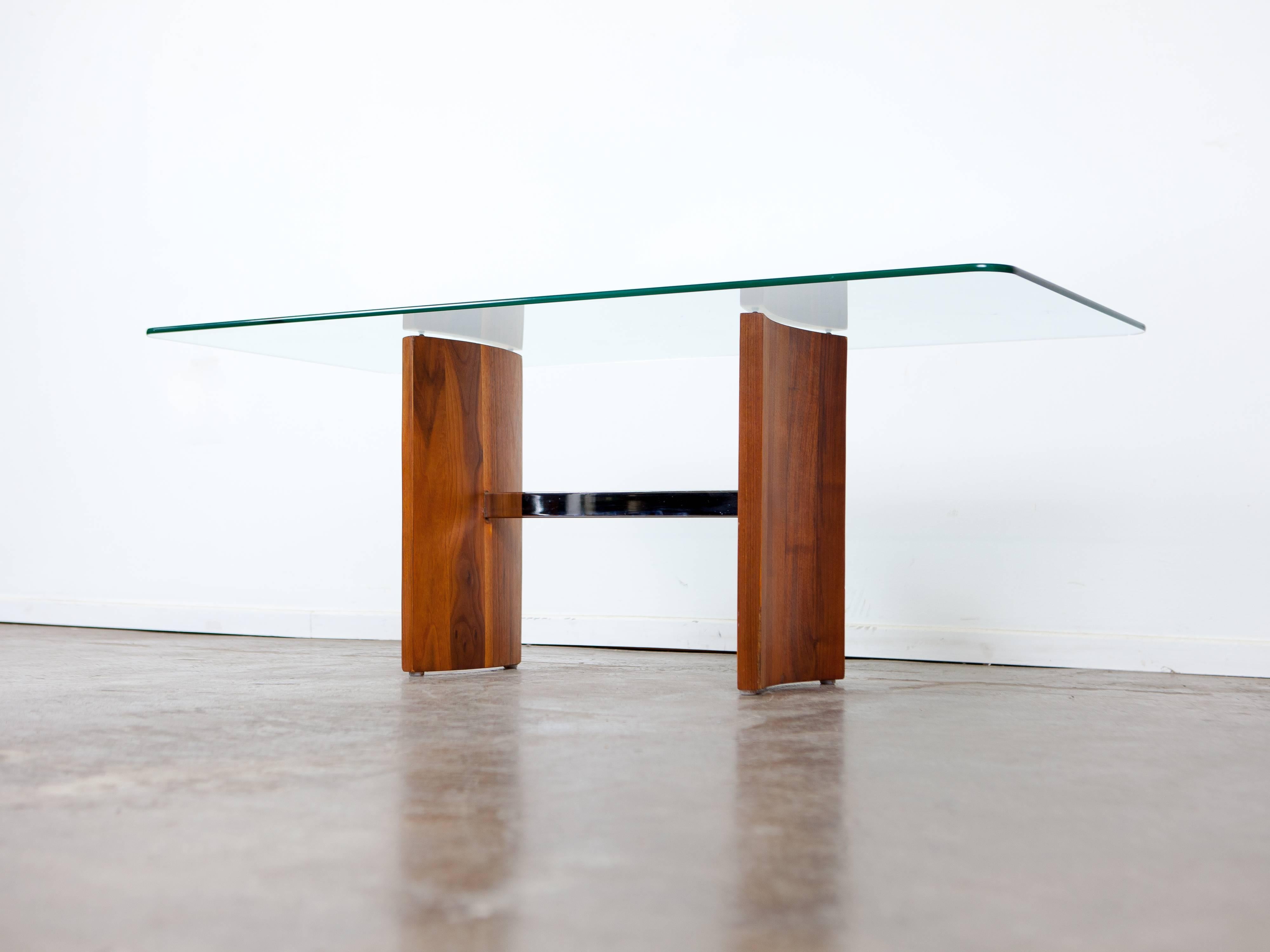 Glass top coffee table with solid walnut base and metal support.