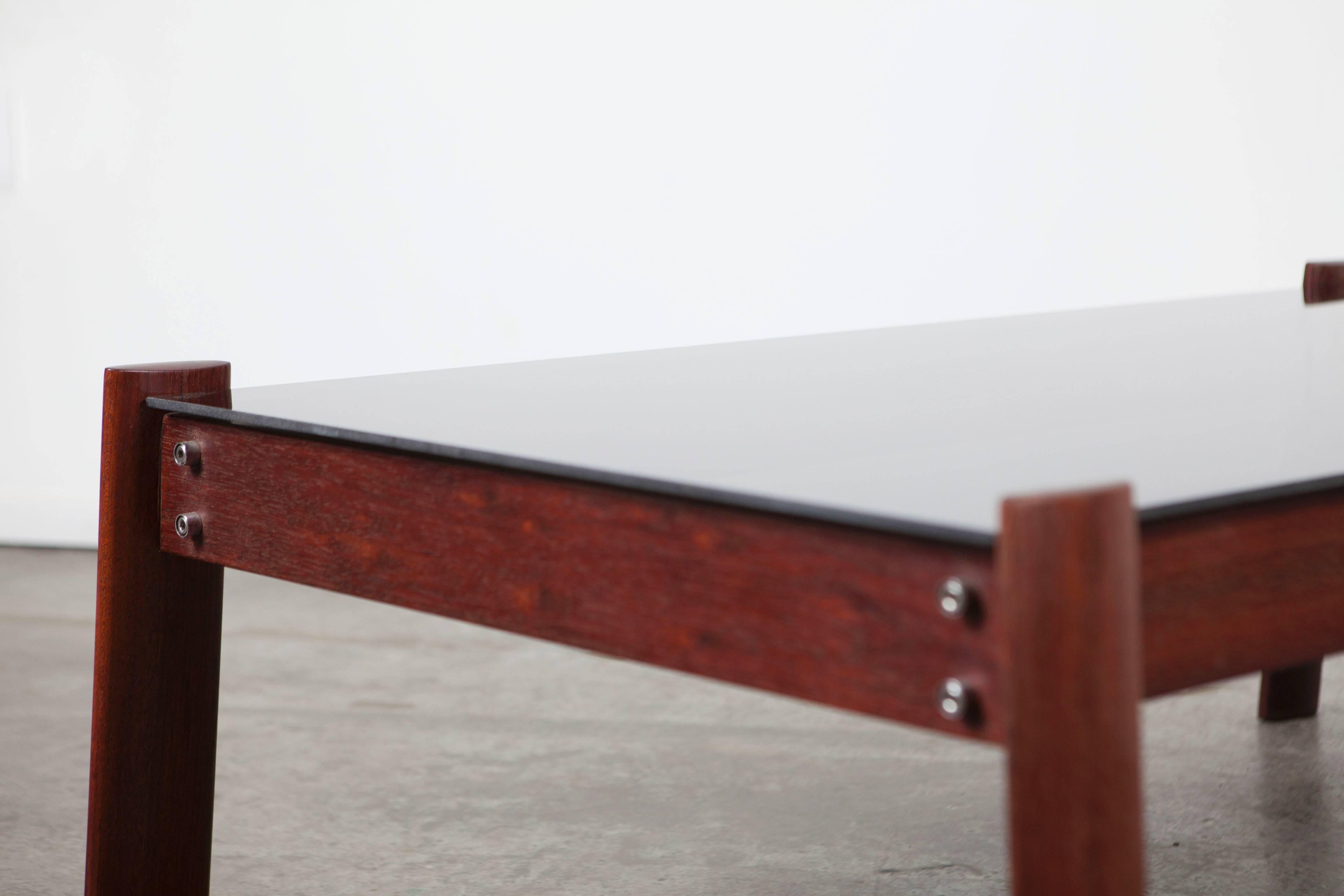 Sleek and simple percival laffer smoked glass coffee table with rosewood frame.