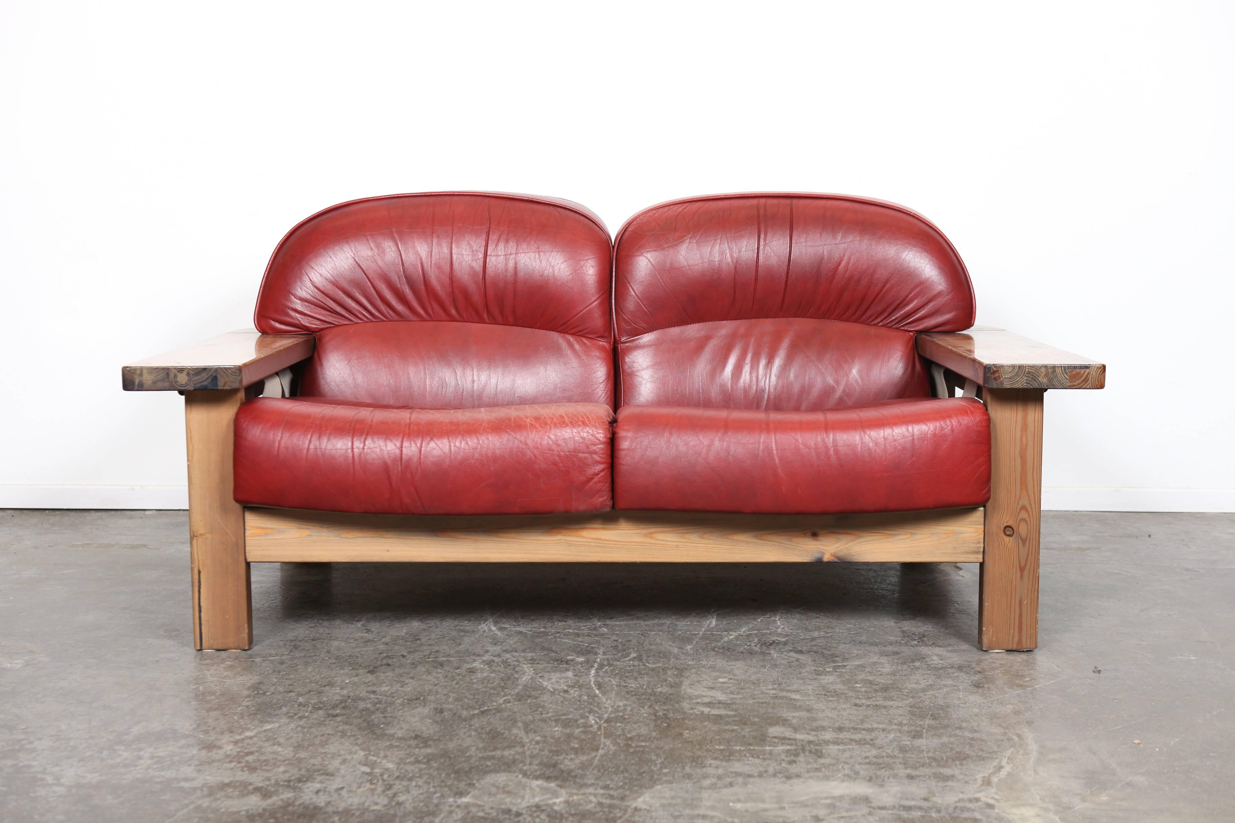 Mid-Century Modern very unique solid pine two-seat sofa with original curved red leather cushions, designed by Hämeen Kalustaja,  Finland, 1970's. Matching three seat sofa available for purchase separately.