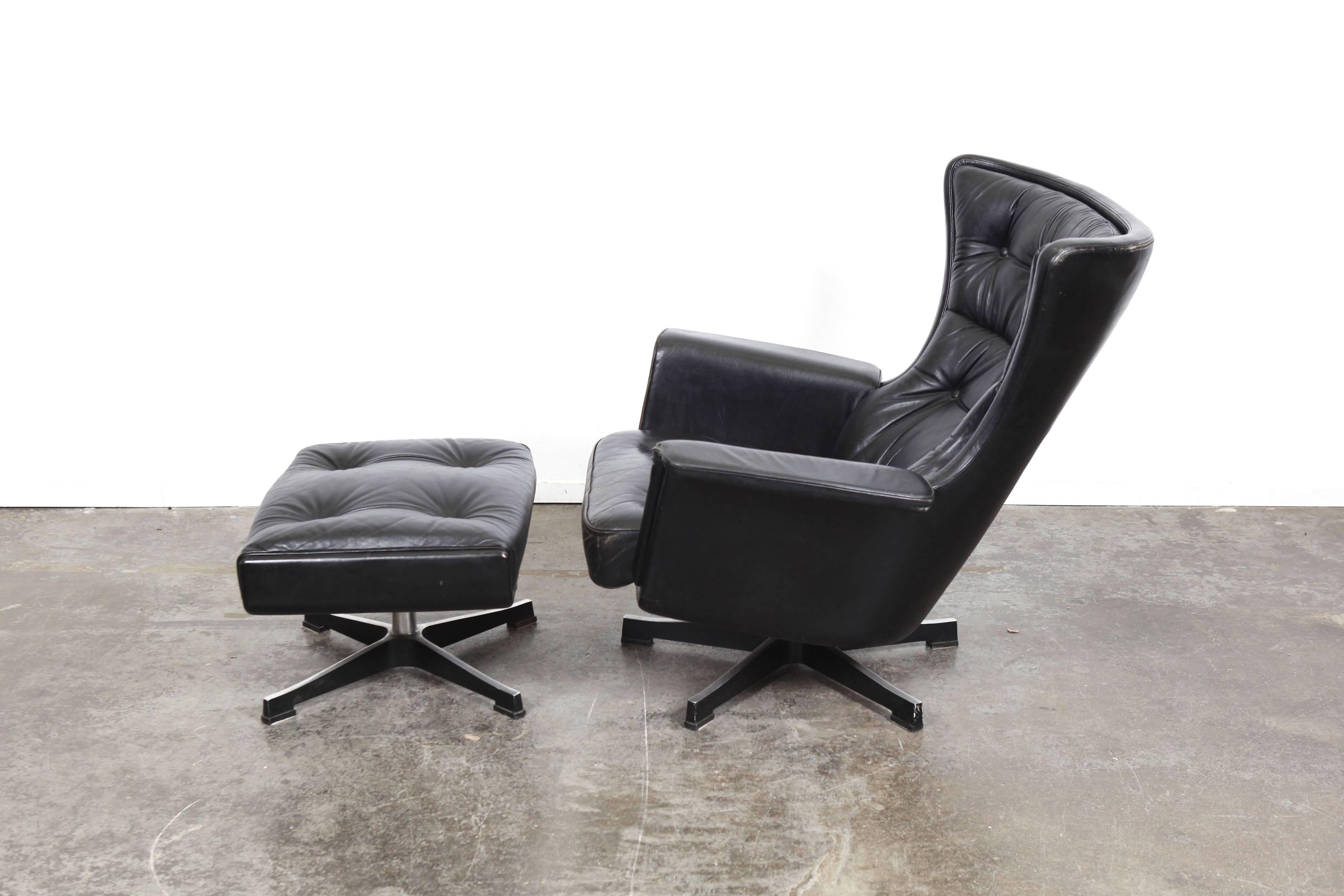 Swedish Mid-Century Modern vintage black leather swivel lounge chair with ottoman, designed by Karl Erik Ekselius for JOC Mobler. Both pieces are in original black leather.