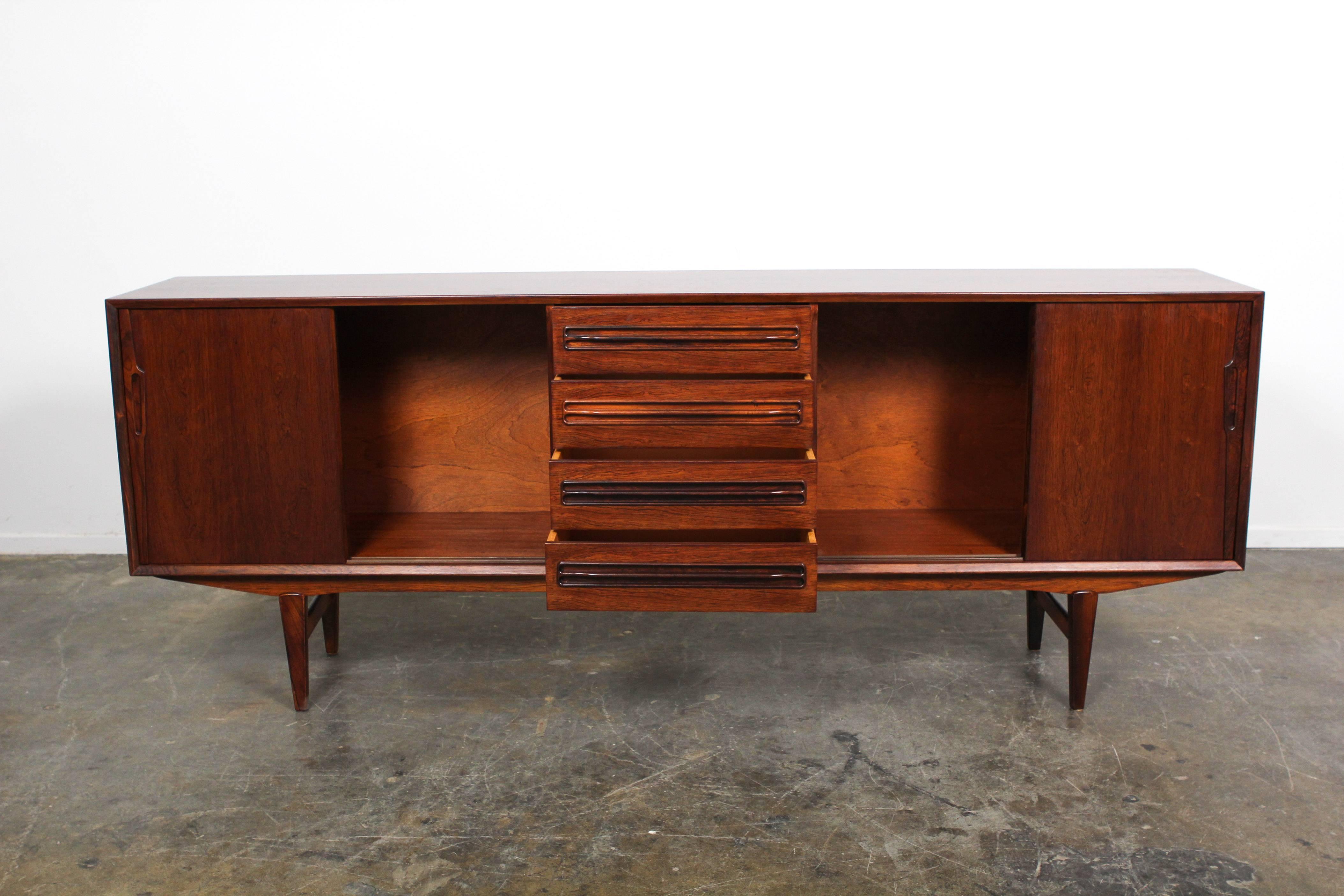 Danish Mid-Century Modern long, low rosewood sideboard designed by Jens Ærthøj and produced by Ærthøj Jensen & Mølholm. Piece has four centre drawers and four sliding doors with sculptural handles and pulls. Newly refinished in lacquer.