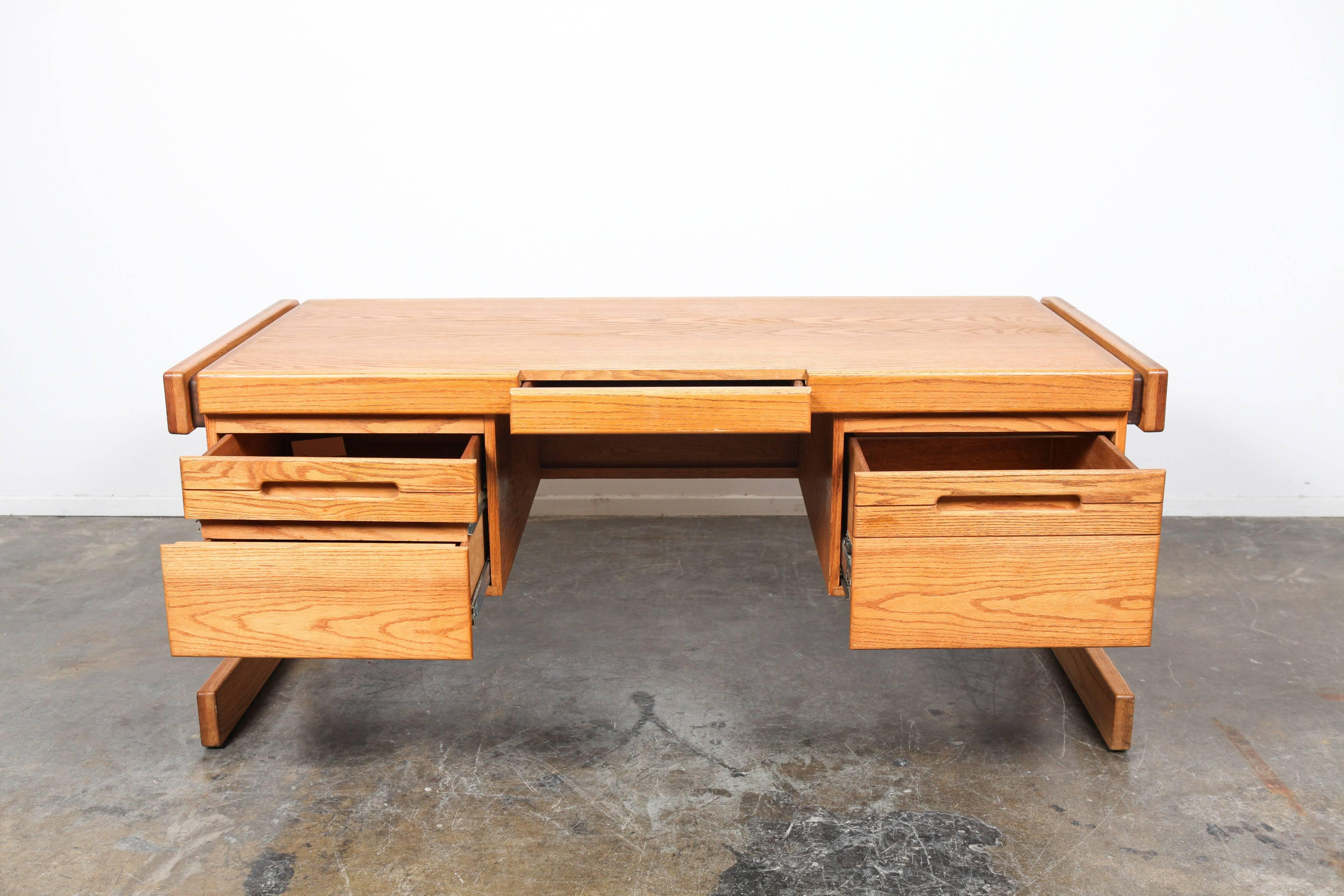 Oak Mid-Century Modern desk designed by American Mid-Century designer Lou Hodges. This piece has a total of five drawers and rests on a U shaped cantilever base.