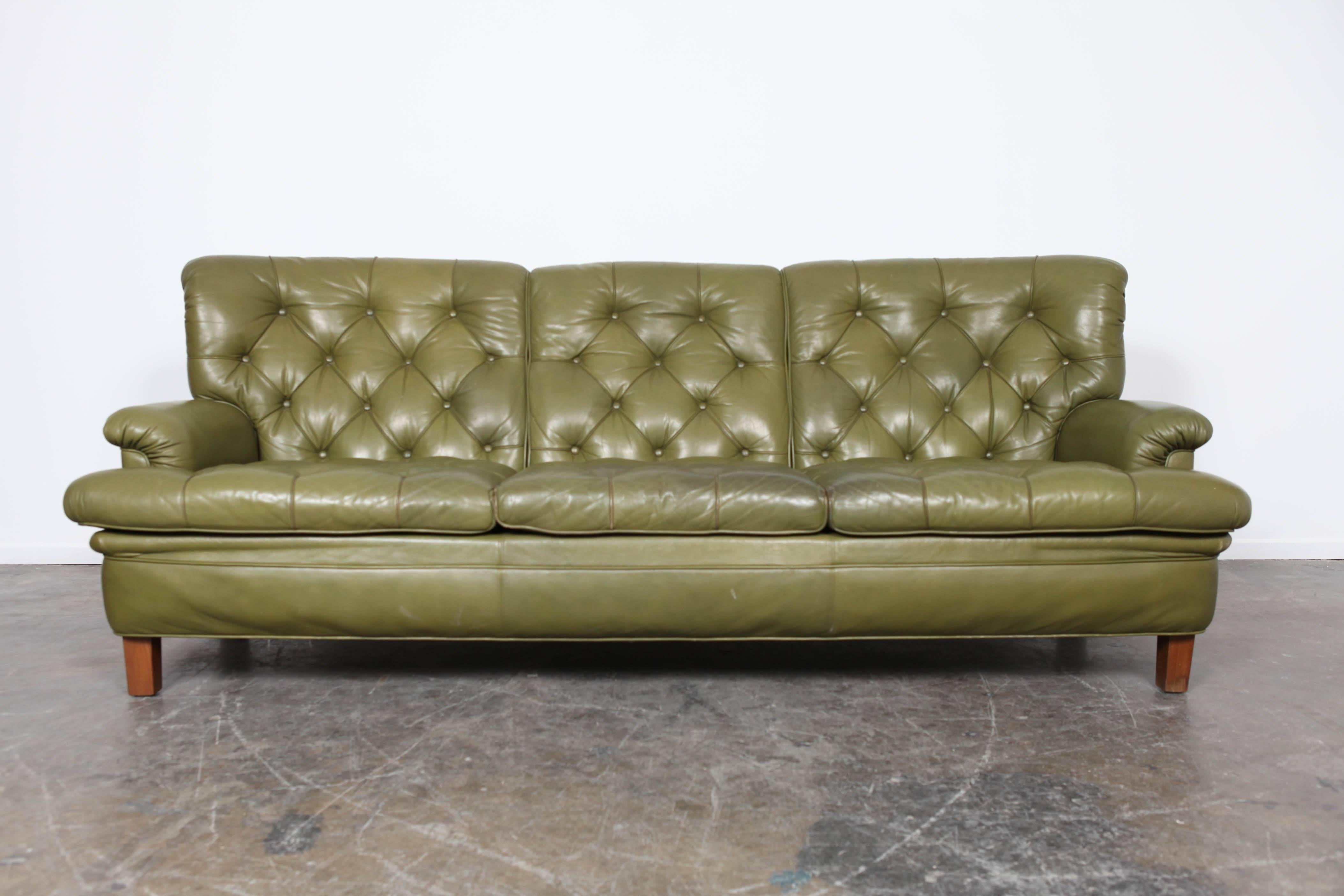 Tufted, three-seat sofa in original, oilve-green leather by Arne Norell.