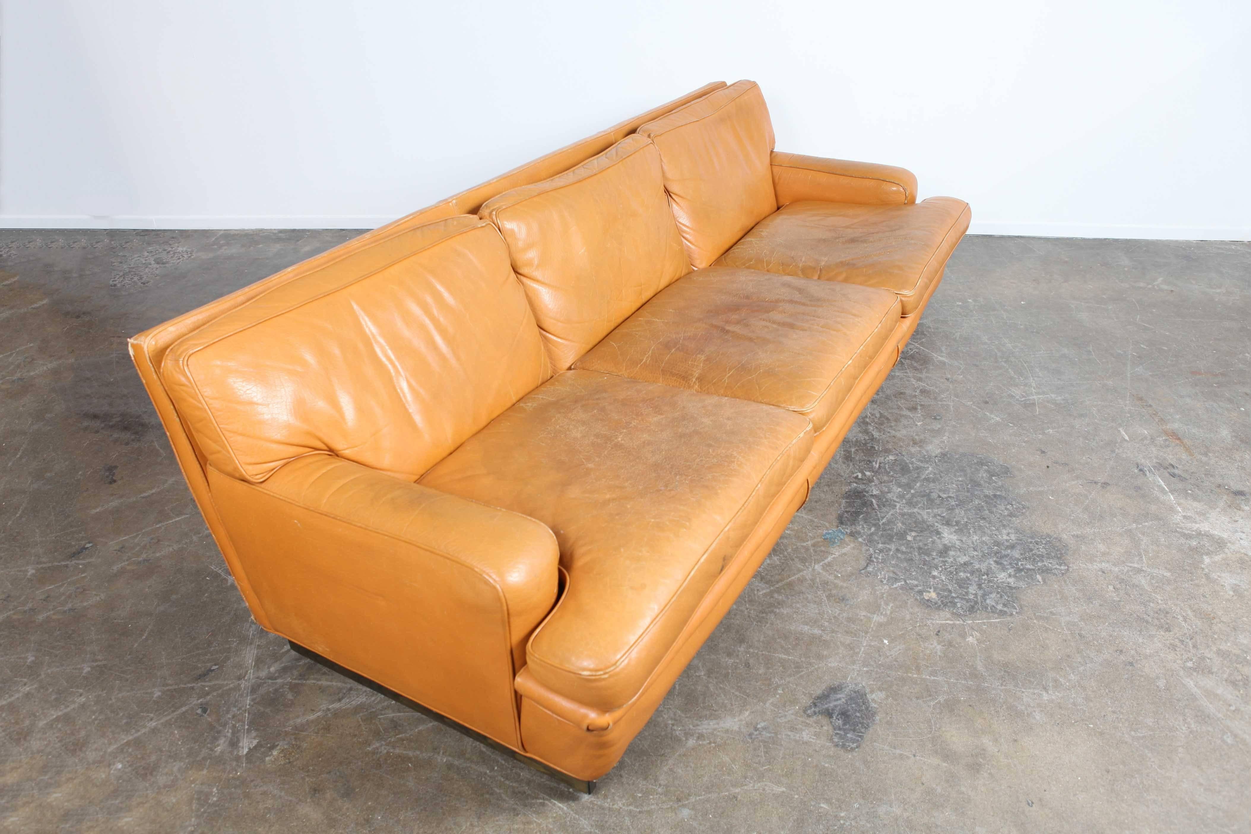 Three-seat camel leather sofa on a plinth base, most likely designed and produced by Arne Norell (not confirmed). Original leather has a wonderful patina to it and it's a very comfortable sofa.