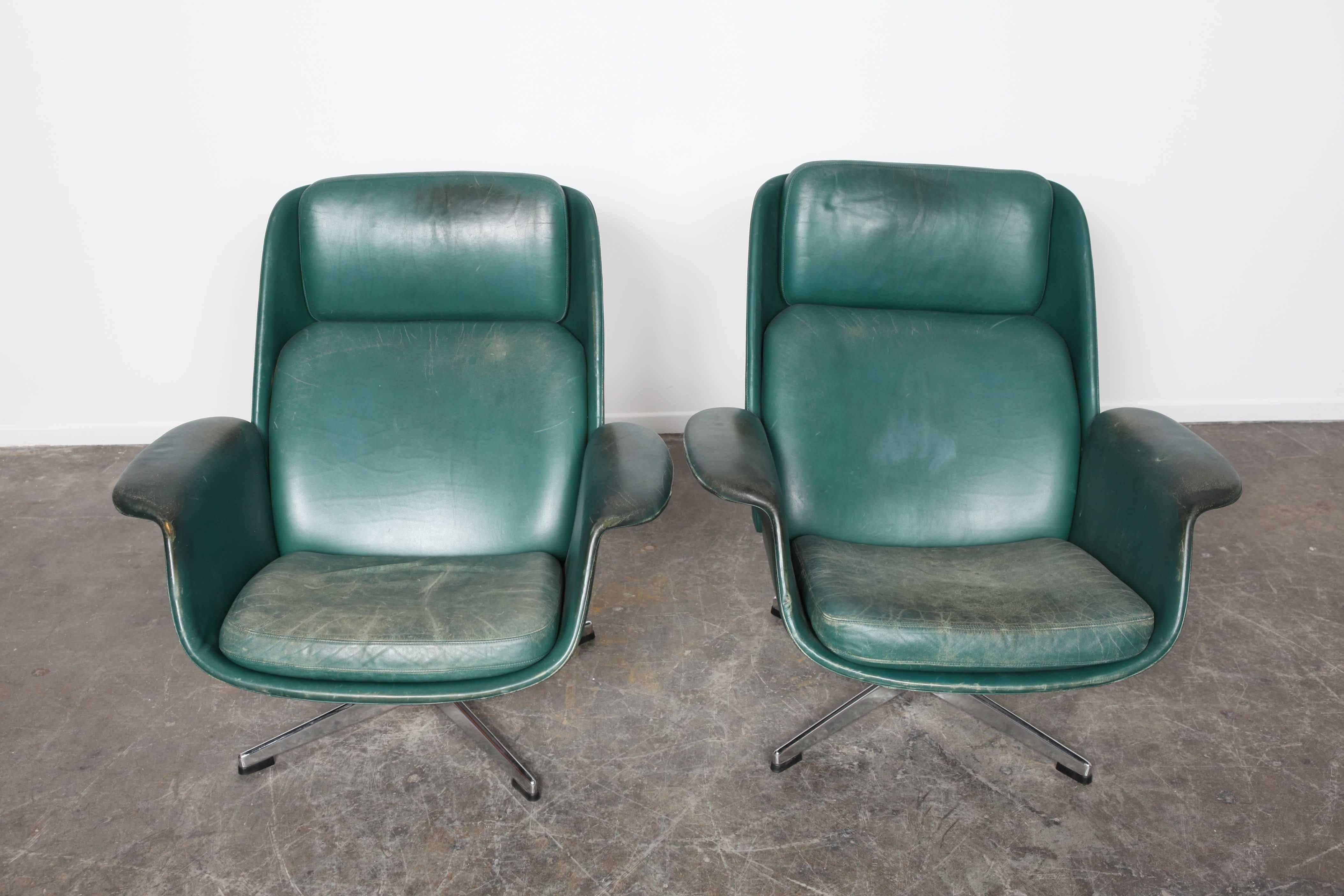 Danish Mid-Century Modern tufted swivel lounge chairs in original deep green leather.
