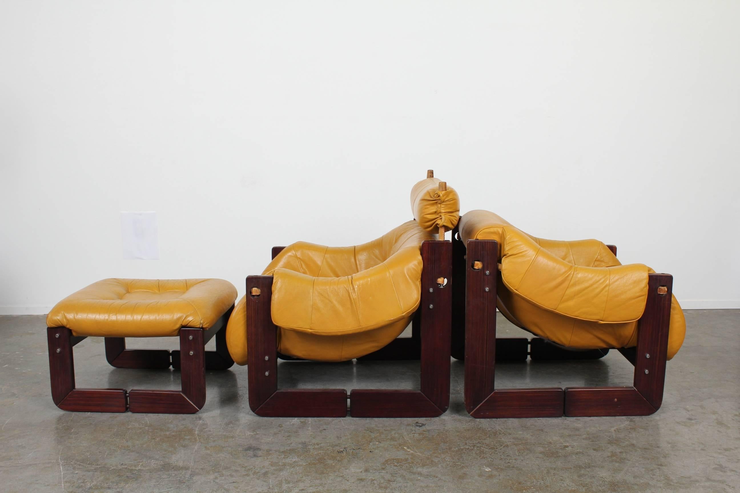 Pair of fantastic vintage lounge chairs and ottoman by Percival Lafer with  Brazilian rosewood and original vintage camel colored leather. Really unique design and construction make this a true statement piece.