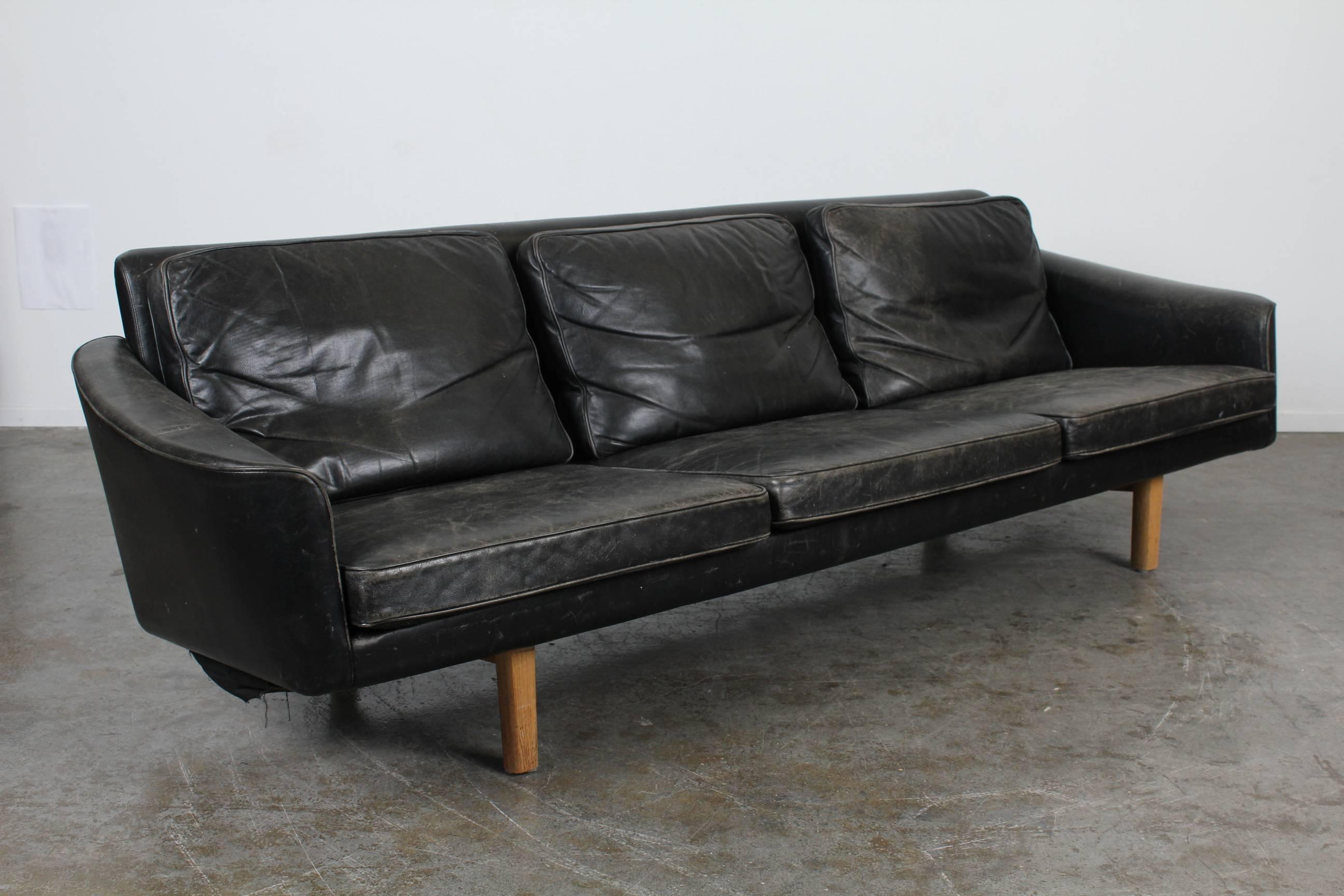 Danish Mid-Century Modern three-seat black leather sofa with beautiful patina.