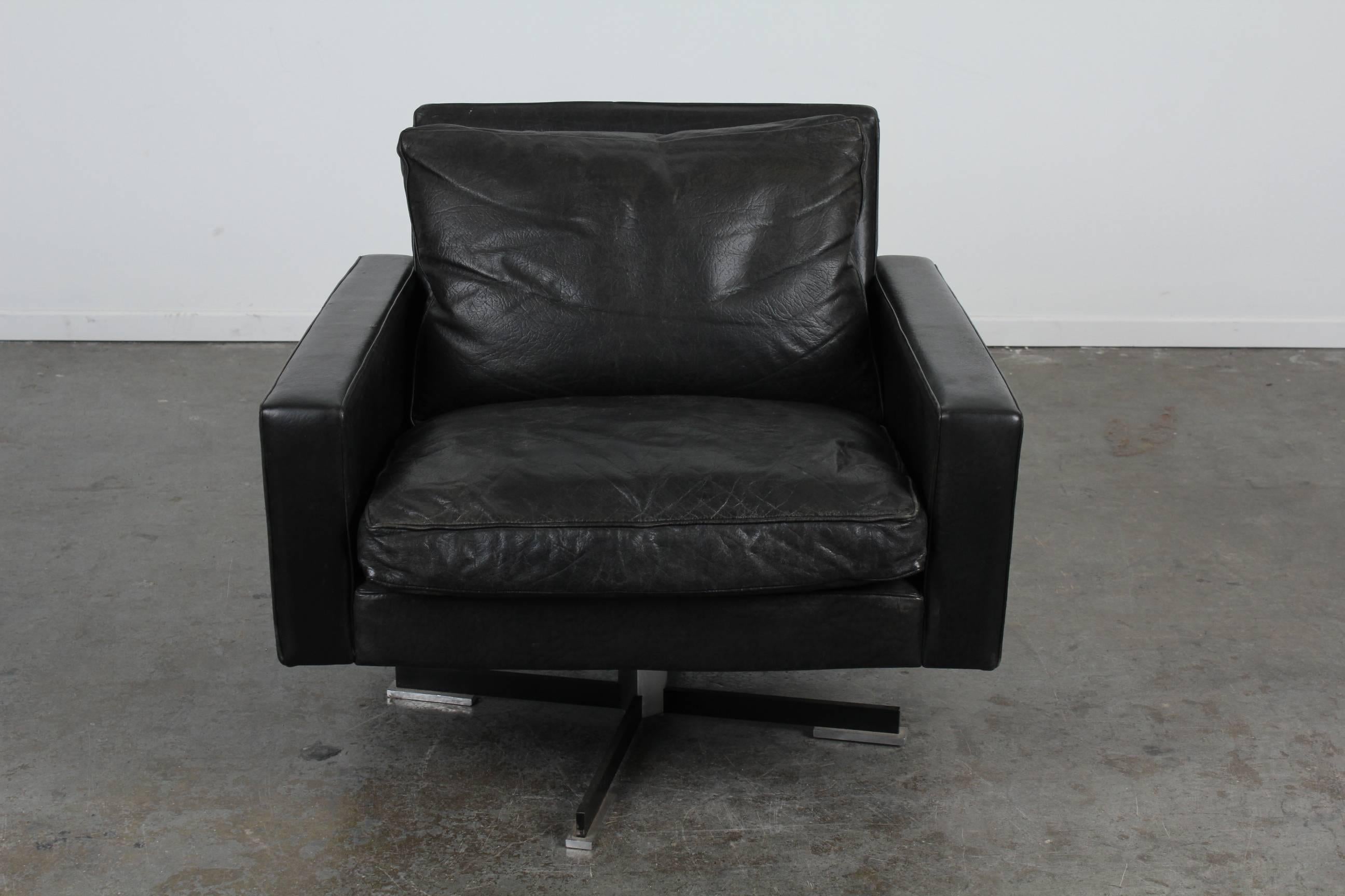 Mid-Century Modern swivel chair with original black leather and chrome legs. Matching sofa available.