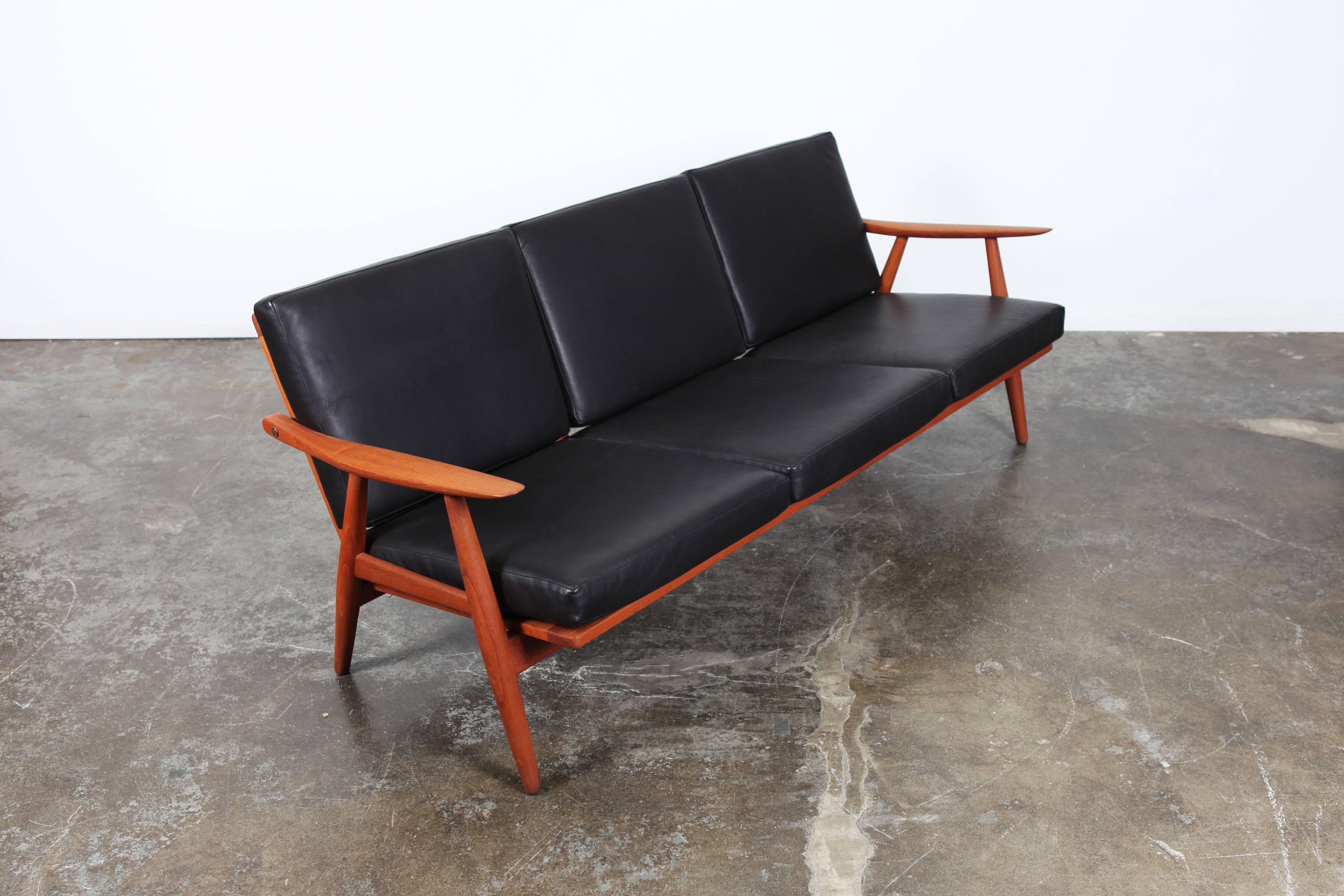 Vintage GE-270 sofa by Hans Wegner for GETAMA, circa 1960s. A Classic design, it's recognizable by its sleek, curved arms and attractively angled rear legs. Newly upholstered in black leather with teak construction.