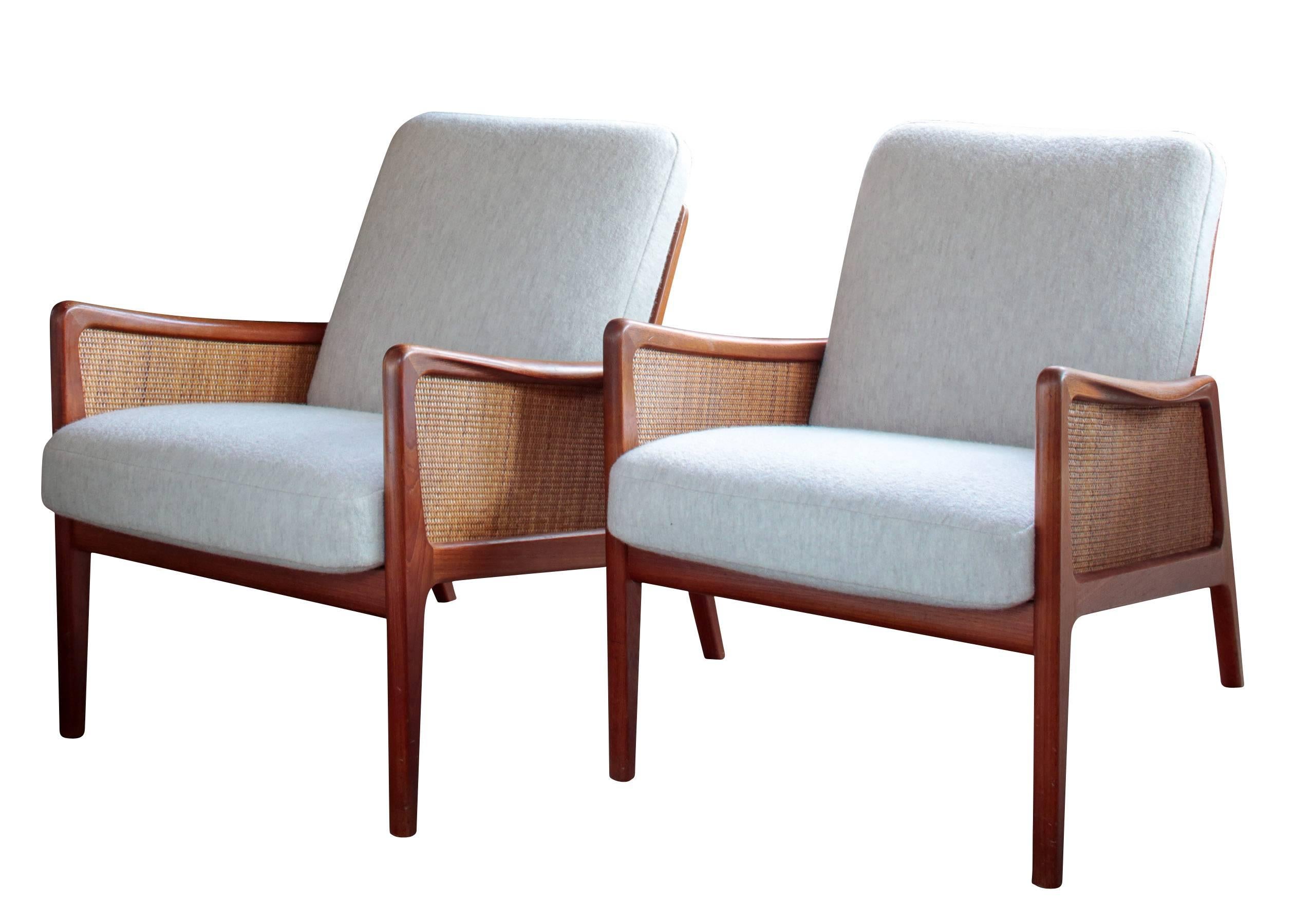 Stunning pair of Mid-Century Scandinavian Peter Hvidt and Olga Mølgaard armchairs. The chairs have been newly re-upholstered in boiled wool while the sides are in teak with original caning.