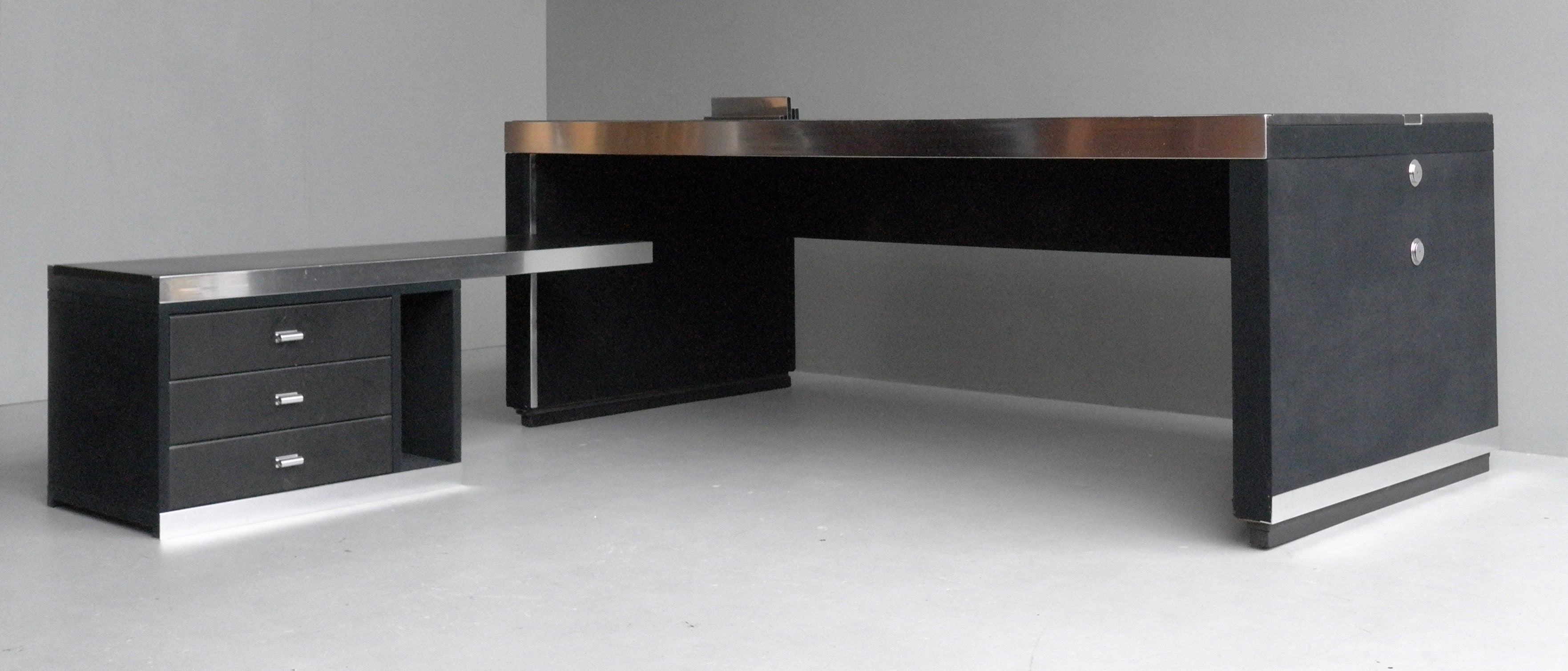 An Italian midcentury L-shaped executive desk by Guido Faleschini by Mariani with a black leather top and very dark blue faux velvet sides and chrome accents. This desk also features a file sorter that slide within a unique recessed channel.
A