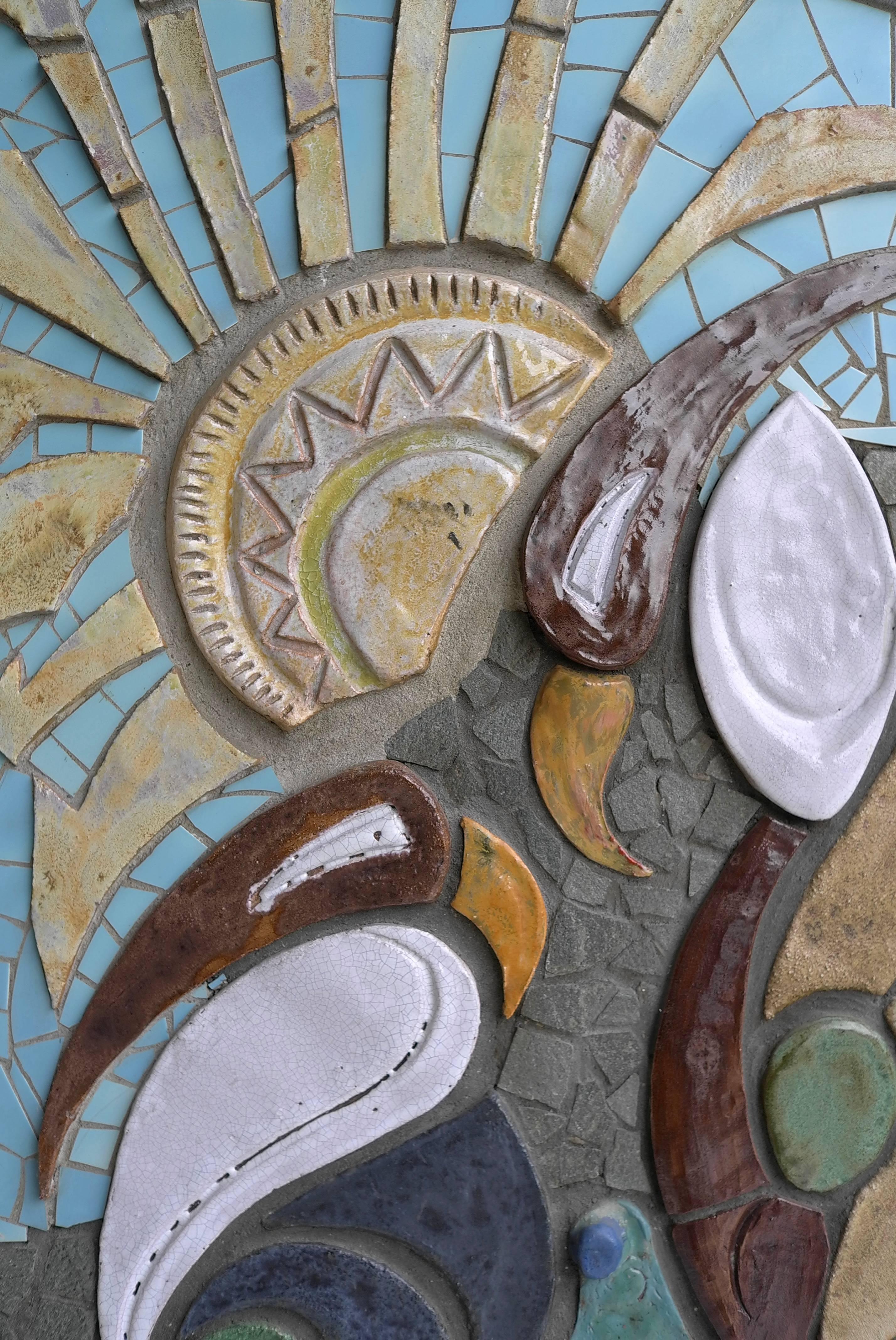 Large ceramic wall sculpture with exotic bird and Sun image.

This wall sculpture was inserted into a wall from a 1960s villa.
It is handmade by an unknown artist. Techniques: Glazed ceramic in combination with tiles on hardboard. It can be