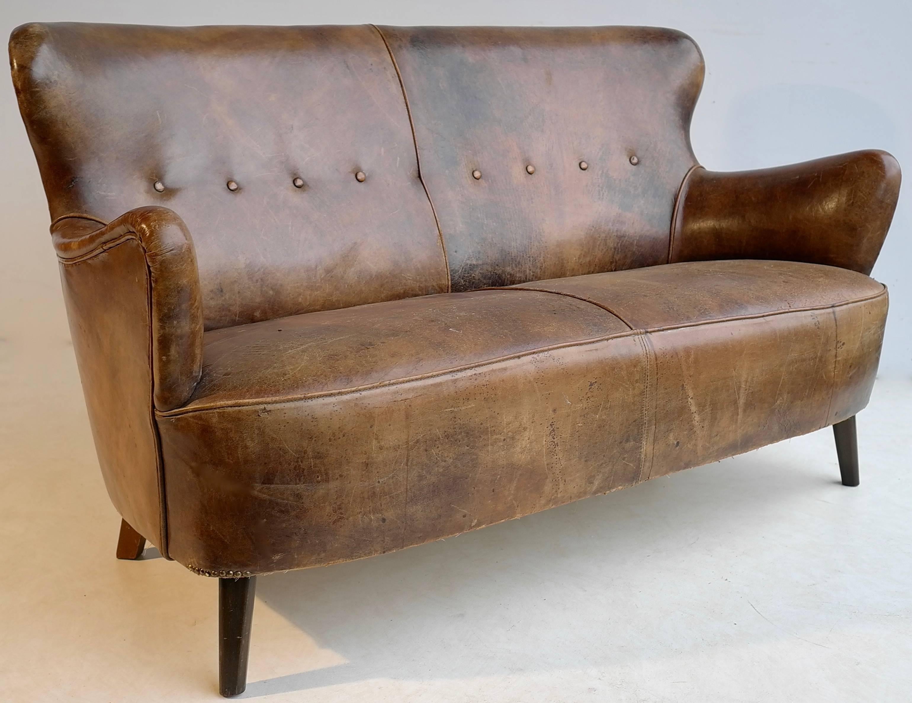 Cognac leather sofa with a rich patina, by Theo Ruth for Artifort.

Wonderful original patina and wear. Broken in like your favorite baseball glove. The sofa has various patina, stains, rubs, scratches and wear. And we wouldn't have it any other