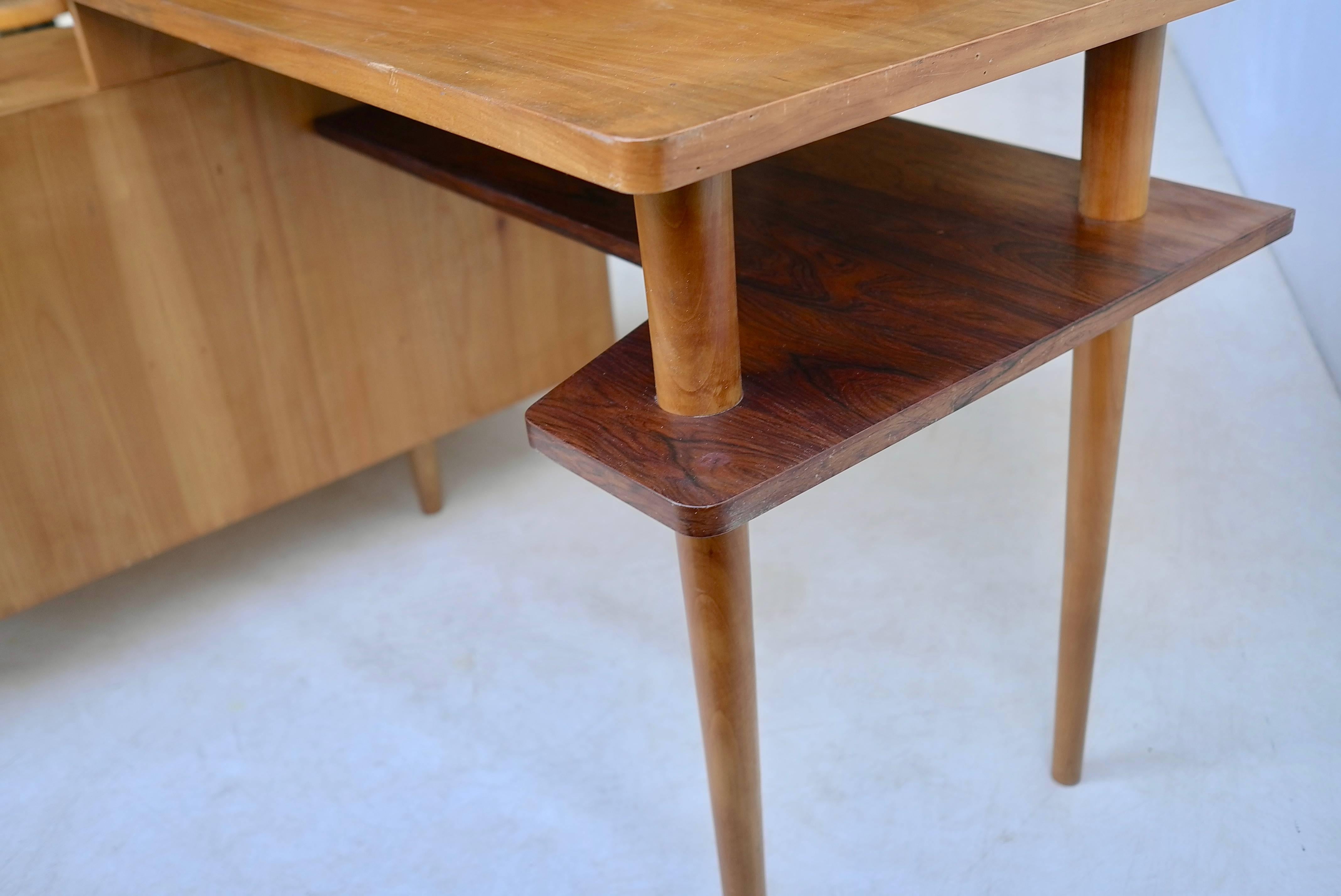 Elegant L-shaped 1950s desk with Macassar Ebony details.
Shelf and handles are from Macassar Ebony, the rest of the desk is probably fruitwood or some tropical sort.