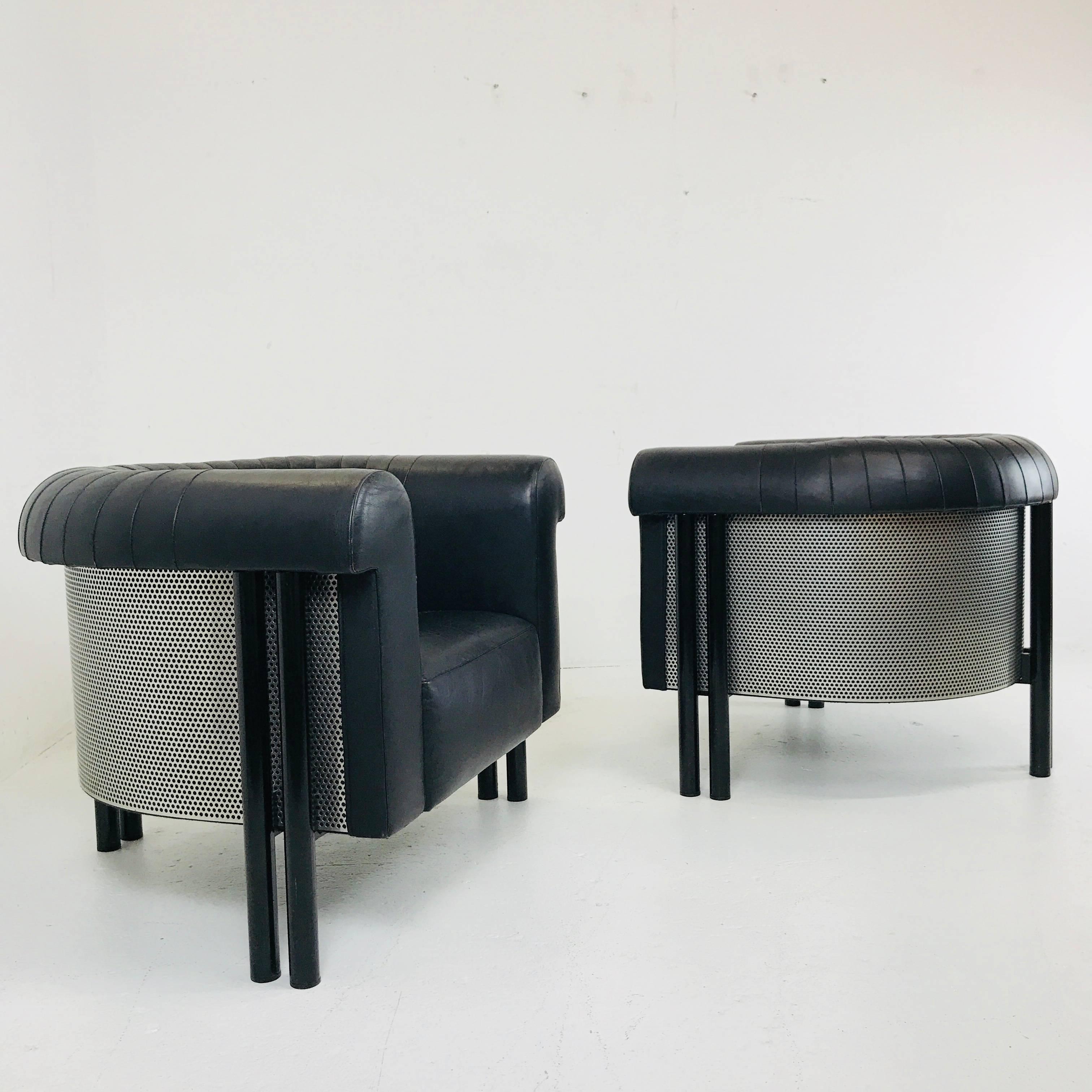 Pair of black leather lounge armchairs by DeSede with perforated metal exterior. Chairs are in good vintage condition with wear from use and age.

Dimensions: 35.5
