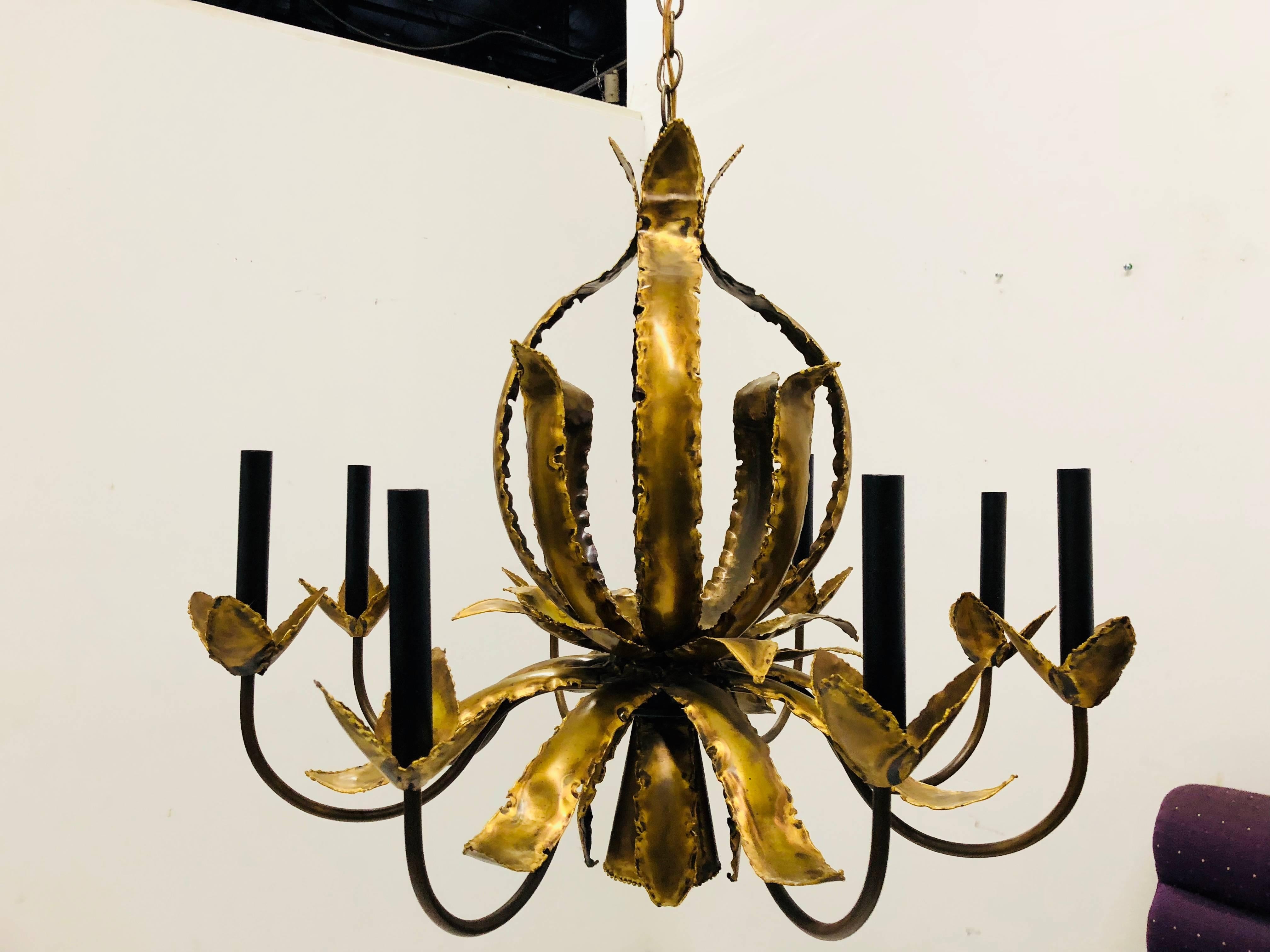 Eight-Arm Torch Cut Brutalist Chandelier with Down Light. In good vintage condition with wear due to use and age. circa 1970s

dimensions: 27