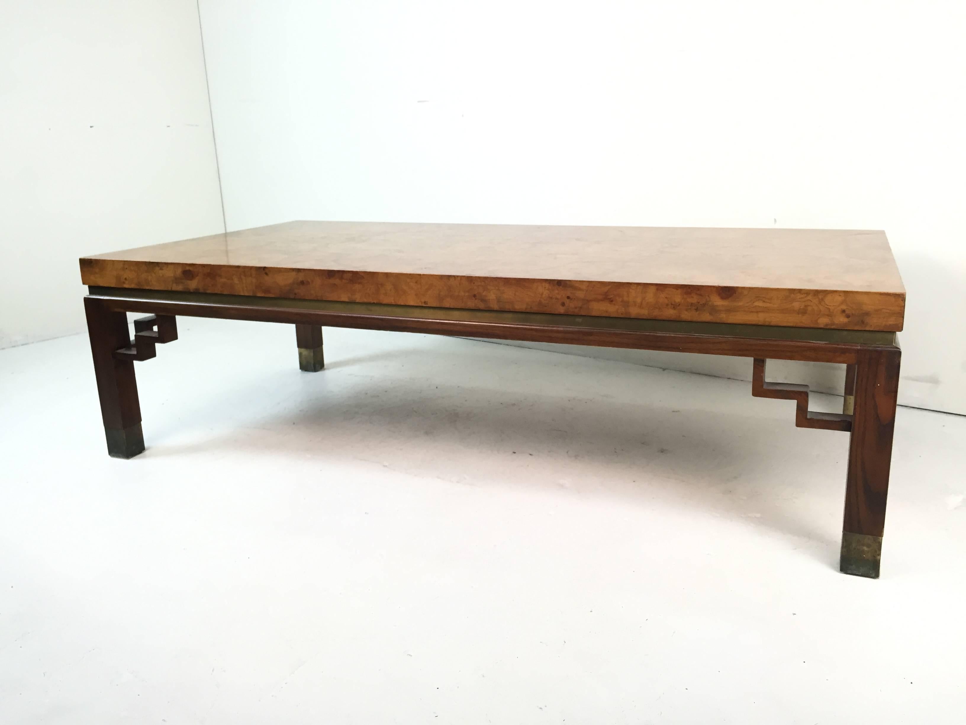 This handsome table is extremely well built and features a beautiful matchbook burl wood top with brass accents and rosewood legs finished with brass sabots.