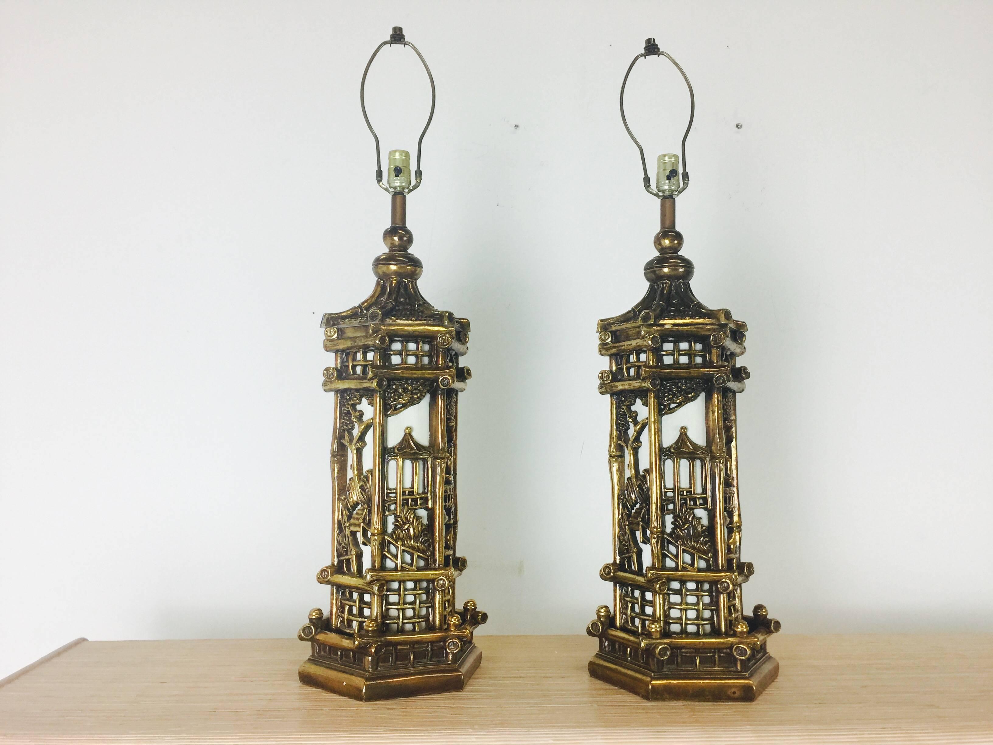 Paar goldene Chinoiserie-Lampen im Stil von James Mont. Diese Lampen leuchten nicht nur von oben, sondern auch im Inneren des Körpers. Die Stücke weisen altersbedingte Abnutzungserscheinungen auf, etwa aus den 1950er Jahren.

Abmessungen: 10