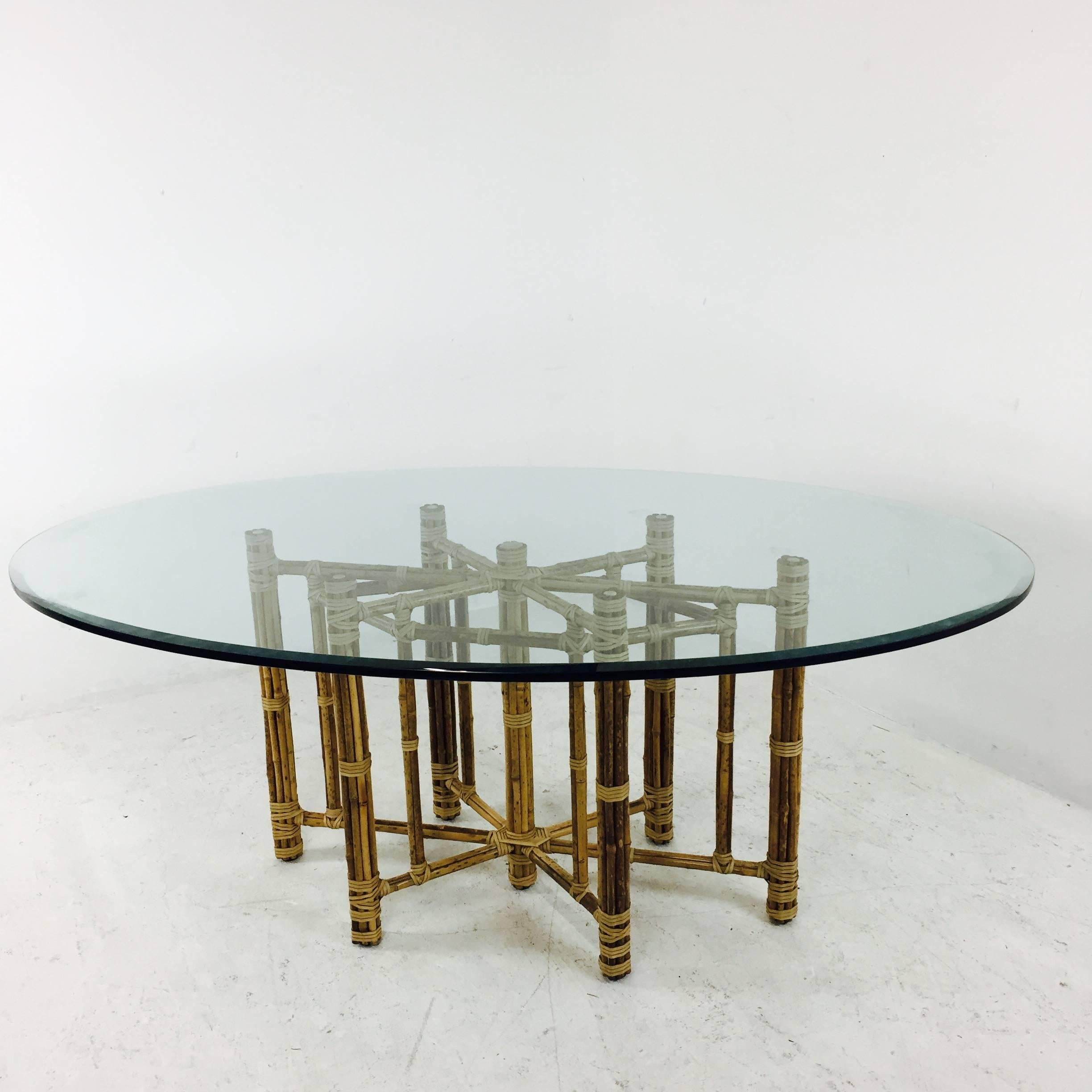 Bamboo oval glass dining table by McGuire with leather straps. The glass is 1/2" thick with bevelled edges with minimal wear. The bamboo has a patina to the finish and can be used as is or refinished, depending on preference, circa 1960s.
See