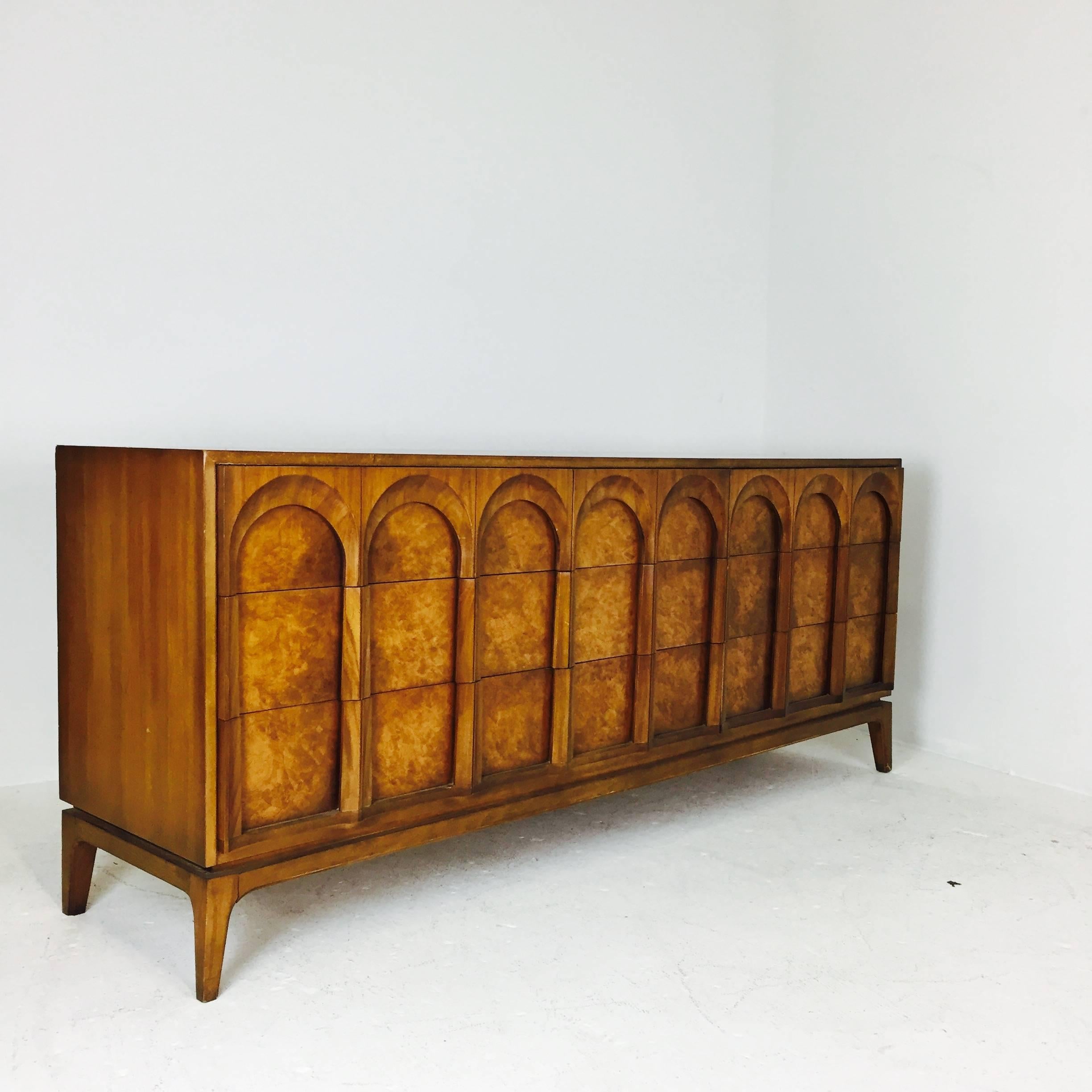 Nine-drawer burl and walnut arch panel dresser by Thomasville. There is visible wear and minor loss, restoration is recommended, circa 1960s.

dimensions: 76" W X 20" D X31" T.