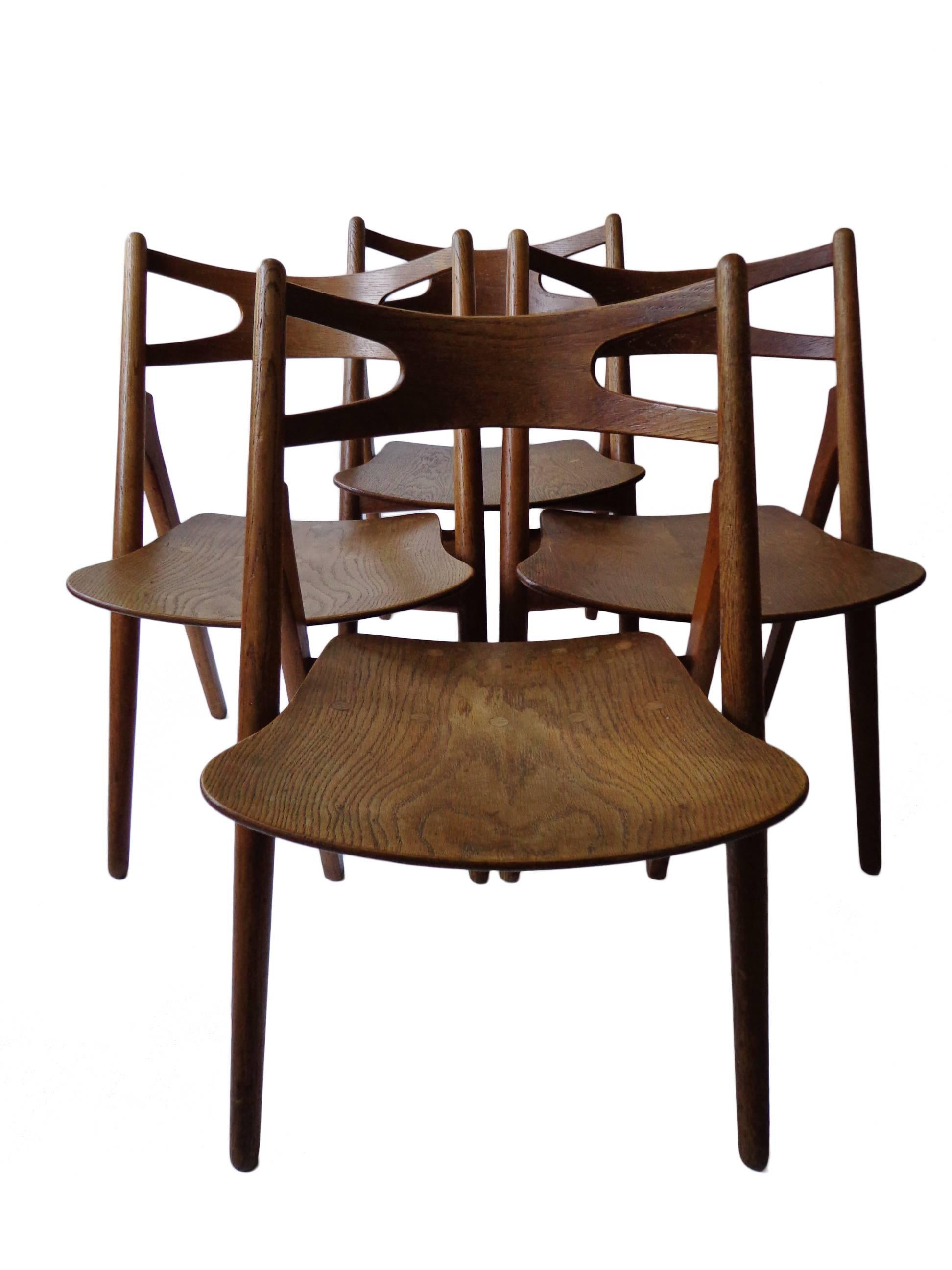 An extremely comfortable dining chairs with visible assembling's that, despite its appearance, is very stabile. The chair's design, which recalls that of a sawbuck.

Signed with branded manufacturer's mark to underside of each