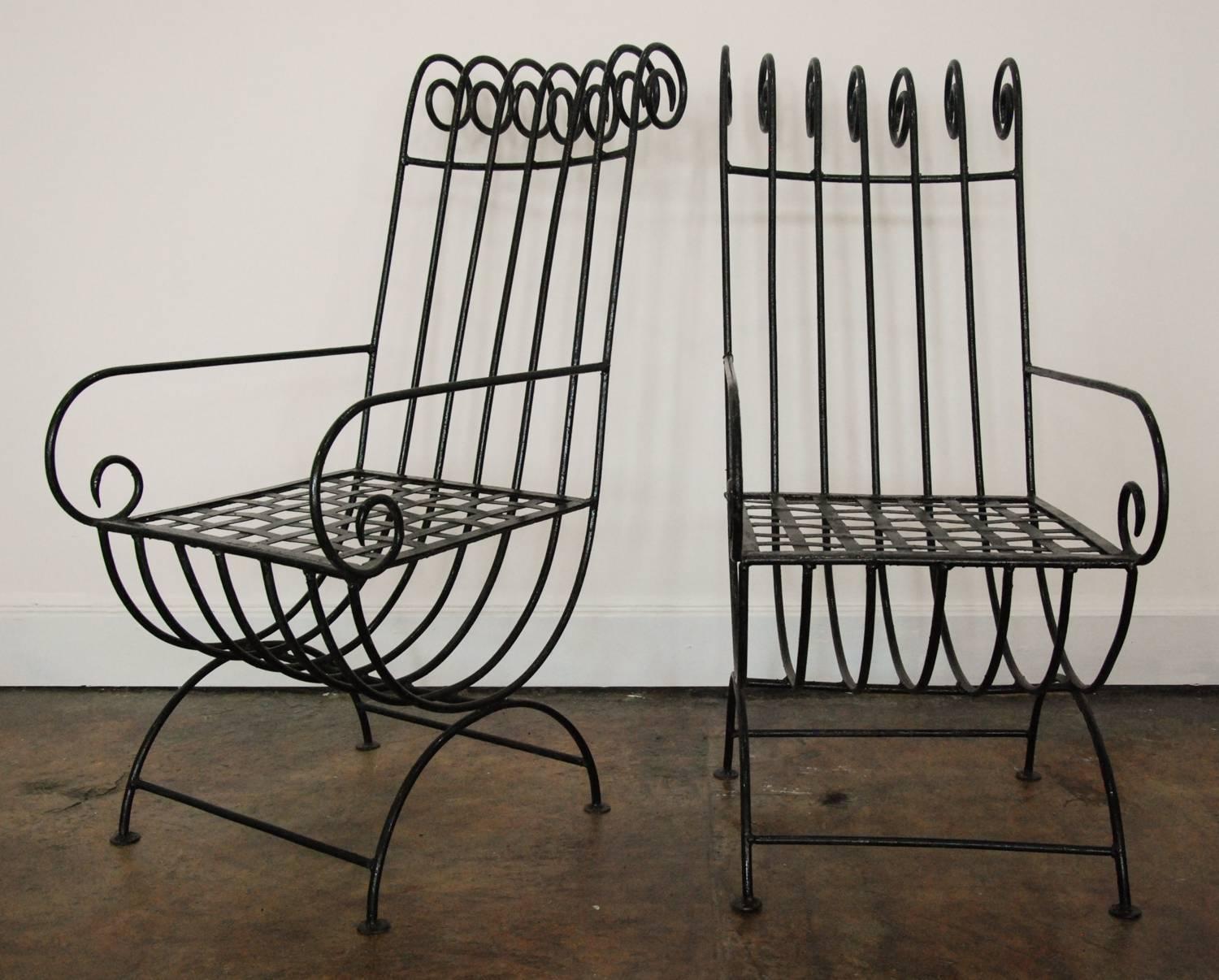 A dramatic pair of highback, French, 1940s style iron garden chairs in the style of Mathieu Matégot with curved armrest and back scrolls. In as found originl black painted finish.