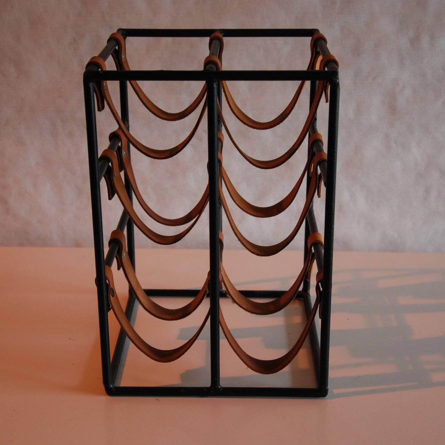 A striking six bottle black enameled steel and leather wine holder by noted furniture and accessories designer Arthur Umanoff for Raymor. This would be a wonderful addition to your kitchen counter top!
  