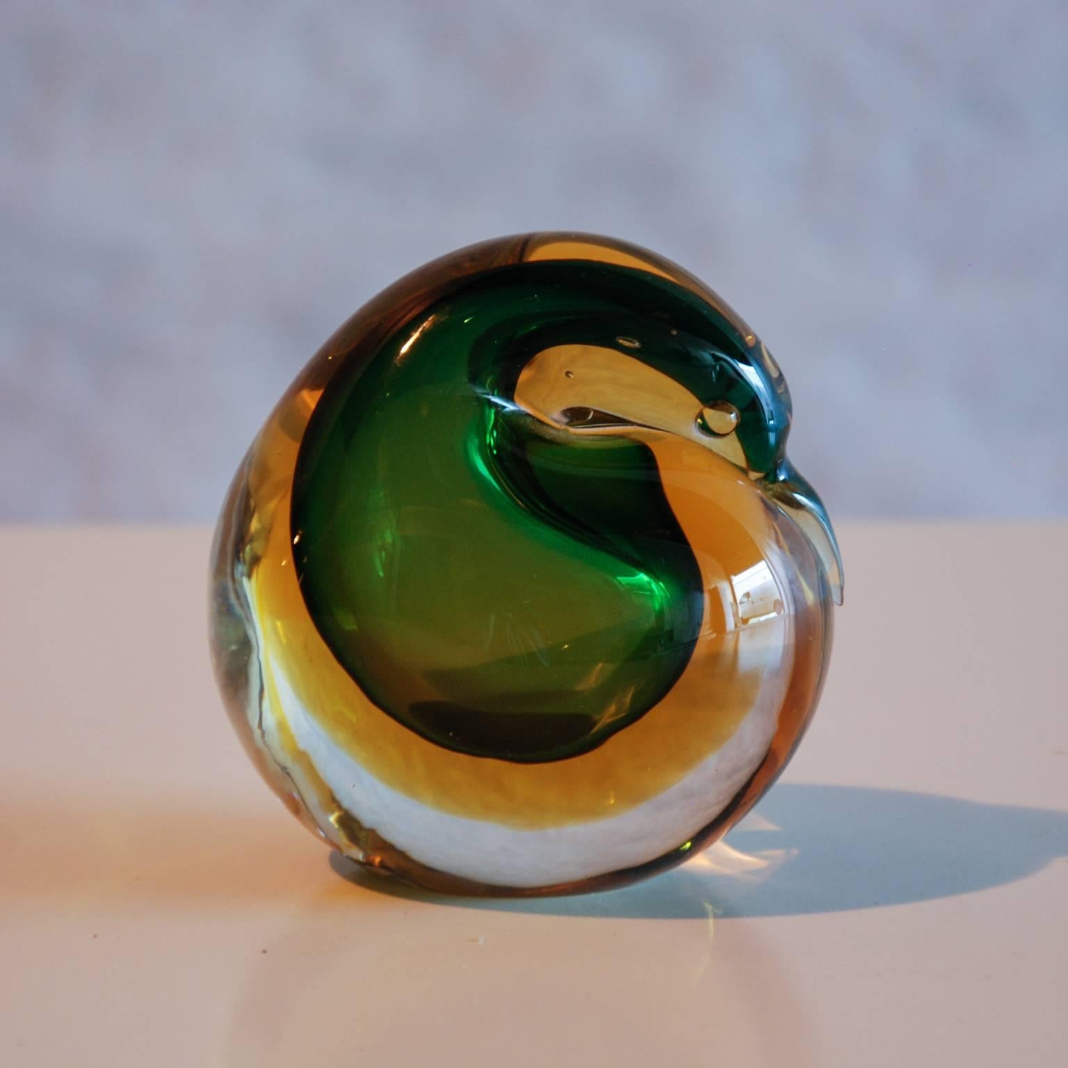 A whimsical art glass bird at rest by Flavio Poli for Seguso Vetri D'Arte.  The bird is executed in the sommerso technique with green and yellow glass cased in clear.