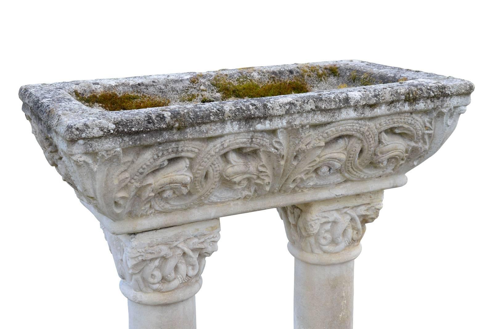 Dating from the 19th century, antique Romanesque style composite stone stoup. It is composed of a basin carved with acanthus leaves and windings resting on two columns feet with fantastic animals decorations on the capitals. The feet rest on a