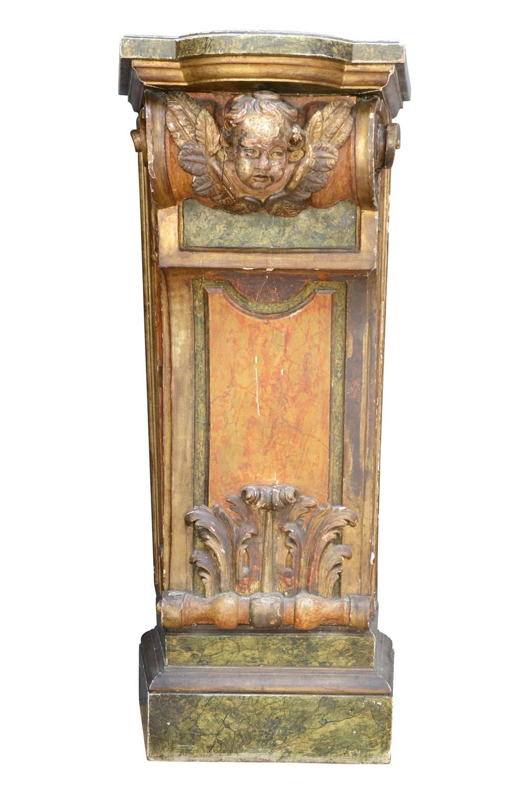 Pair of carved wood and painted consoles, Italian work dating from the early of 20th century. A cherub head located on a winding decor and an upright acanthus leaf adorn the front of the console. They are painted with yellow, green and golden. The
