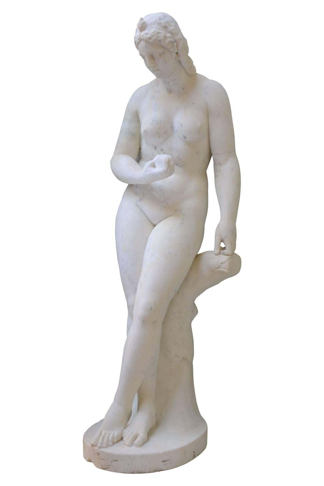 Dating from the 18th century, important Carrara marble statue of Venus with apple. She is lasciviously sitting on a tree trunk, cross left leg, gently tilted look, she has the golden apple offered by Pâris. Venus triumph, here, in all its nakedness