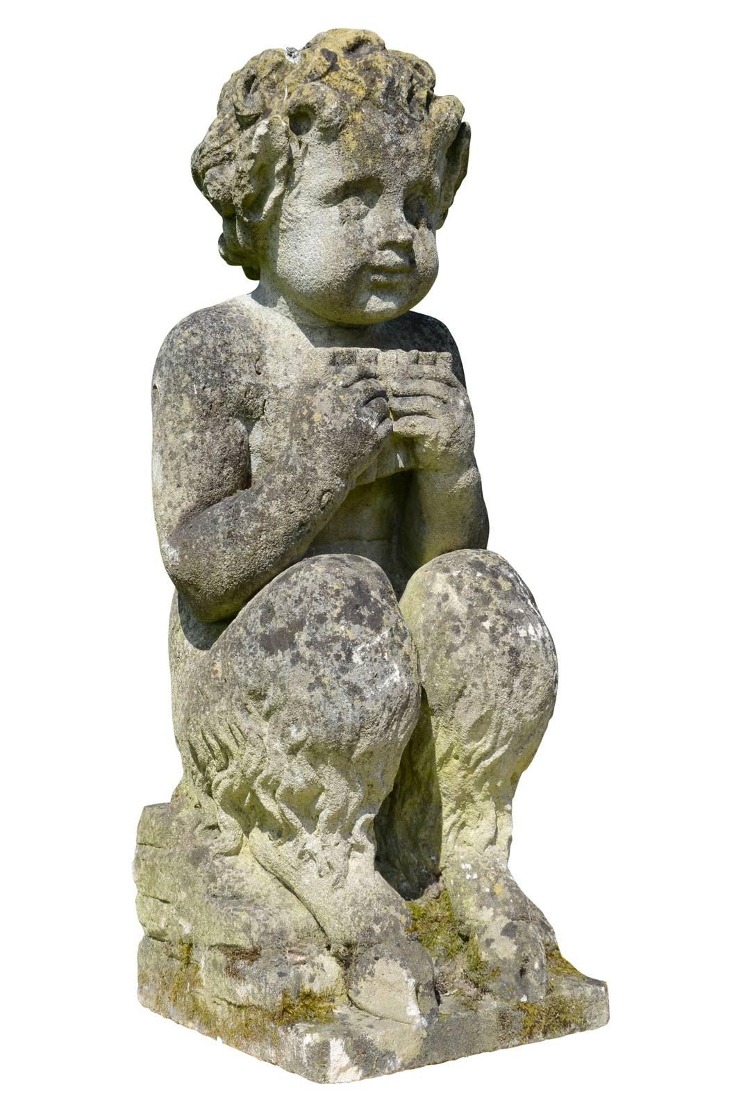 Dated from the 19th century, circa 1870, stone statue of a little satyr. Sitting on his goat legs, he holds in his hands a pan flute. From his curly hair escape two horns and pointy ears. A mischievous air emerges from his face. Restoration at the