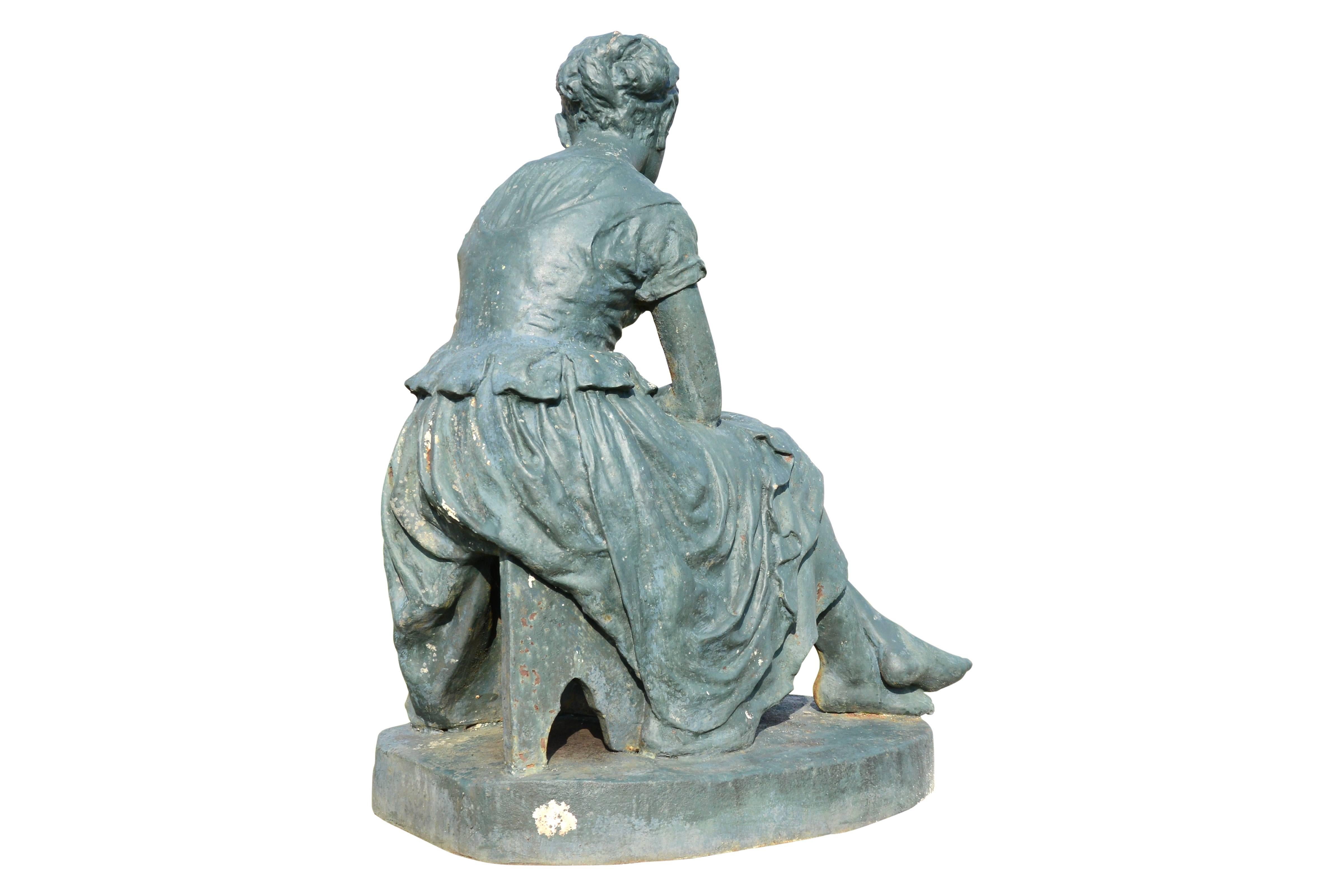 Dated from the late 19th century, circa 1890, cast iron statue representing Cinderella, from Salin foundry. The young girl, wearing a bun and dressed in rags, delicately rests his head on his hand. Next to his bare feet, dragged a ball of wool. On