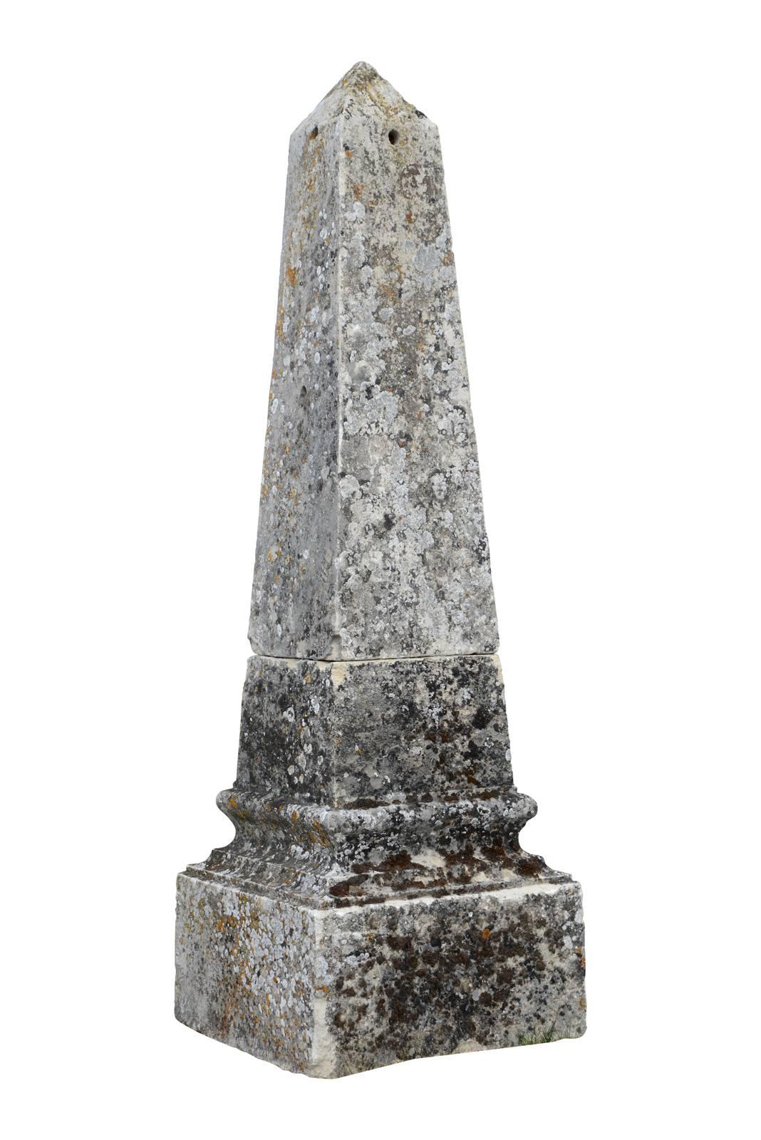 Dated from the 19th century, a pair of molded stone obelisks. Composed of two parts. One has a base of 19.2 x 19.2 in. , while the other measures 21.2 x 21.2 in.