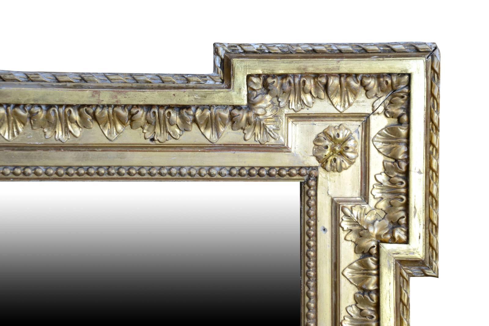Dated from the 19th century, a Louis XVI style gilded wood mirror. Bordered by a double beaded frieze and interlacing, it is topped with a crown of flowers and laurel branches. The two upper corners are animated by rosettes.