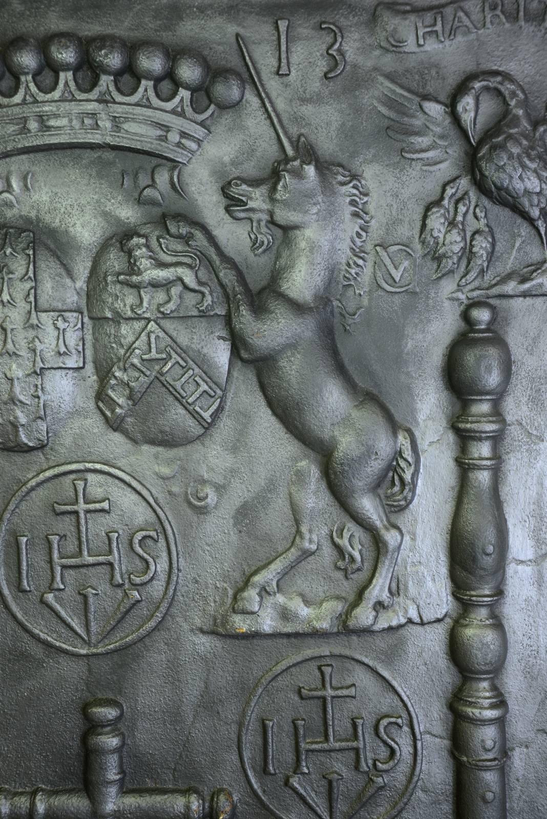 Dated from 1713, large cast iron fireback in Louis XIV period, presenting between two columns of Hercules the arms of the Beaufremont family surrounded by licones. A cross stands in the centre surrounded by five medallions bearing the inscription