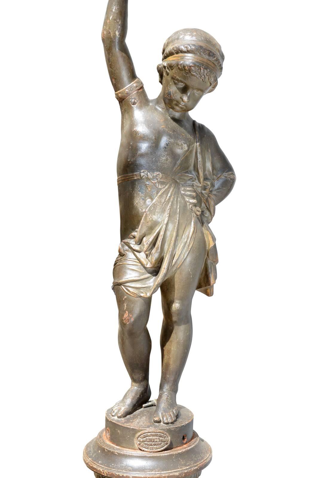 Dated from the 19th century, circa 1870, cast iron torchere by the foundry Girard Frères in Toulouse. It represents a cherub holding a torch in his right hand and wearing a delicate draped. It also rests on a cast iron base decorated with godrons,
