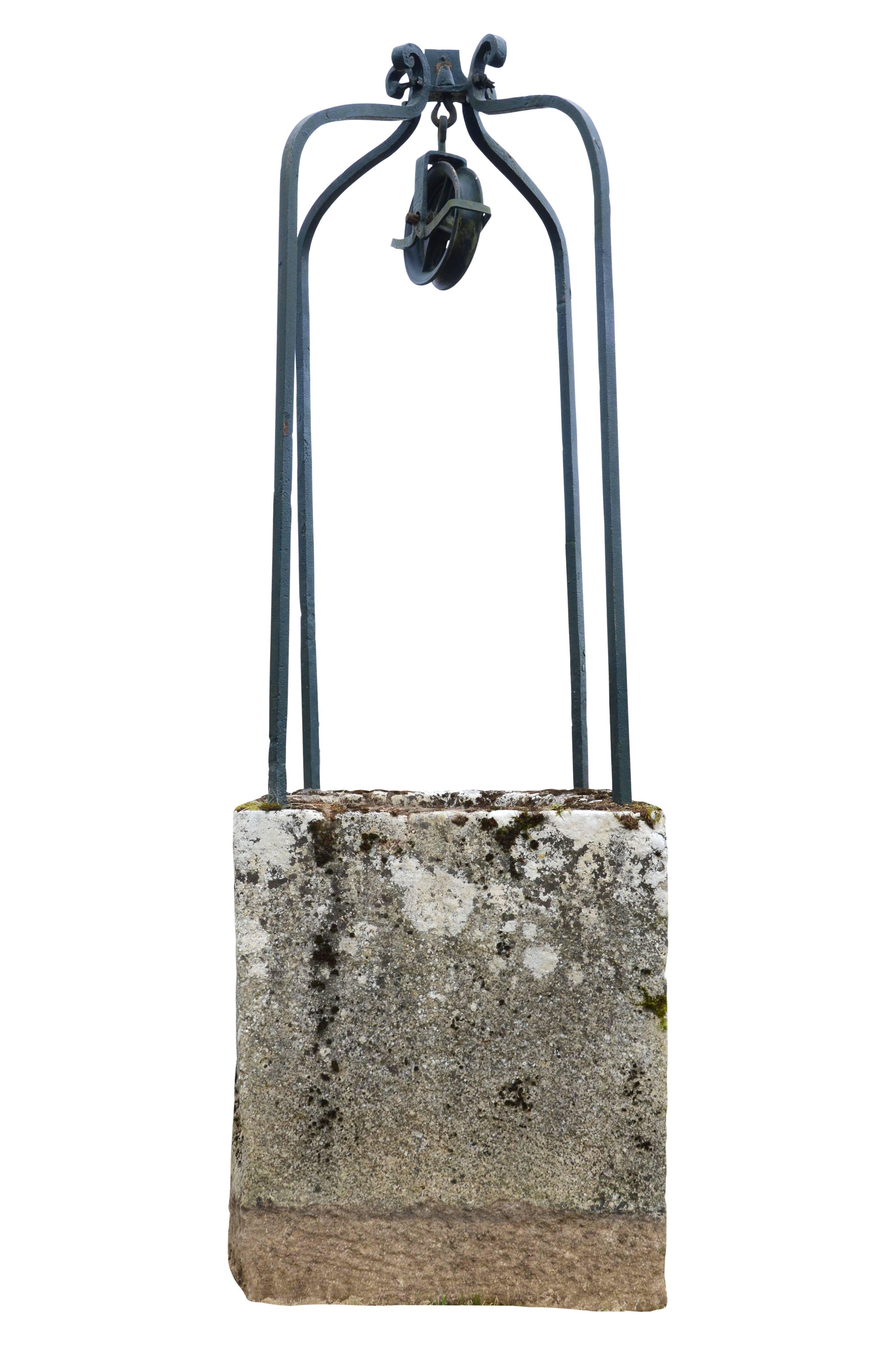 Dated from the late 18th century, stone square well curbstone and its ironwork with pulley decorated with windings at the ends. Dimensions: Total height with the stone wall: 100.3 in. ; stone well curbstone height: 37.4 in. ; wrought iron element