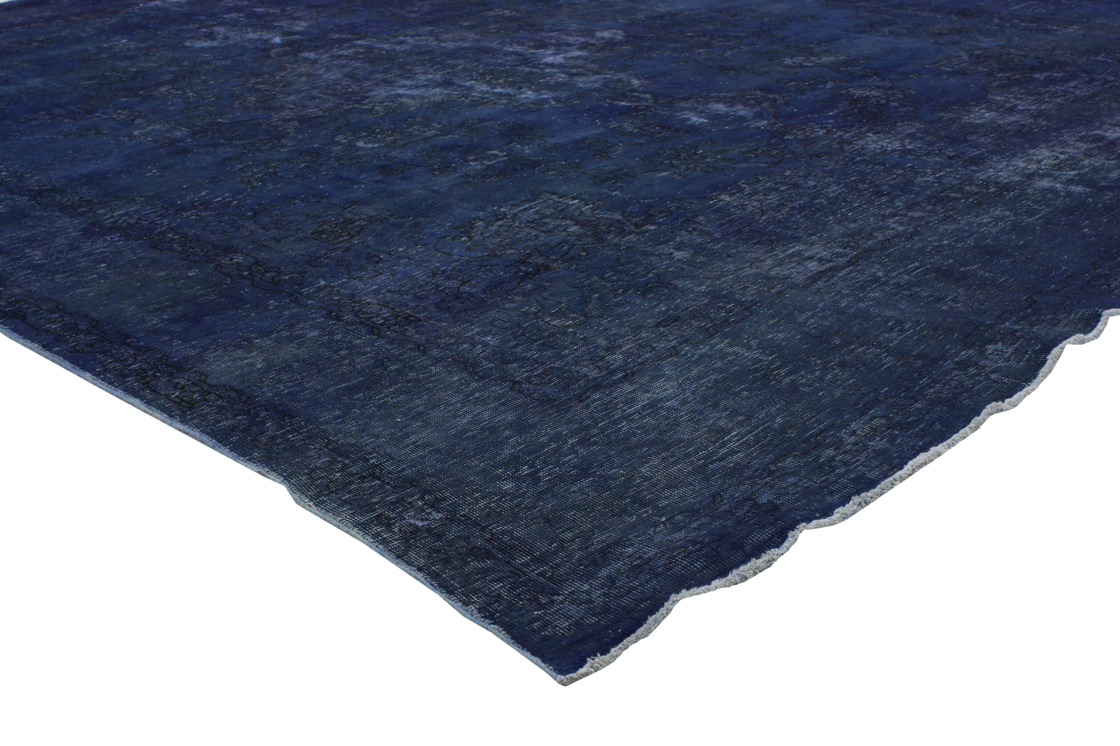 This distressed vintage Persian Tabriz rug overdyed in blue features a modern Industrial style. Characterized by an inconspicuous centre medallion and deeply saturated blue composition, this vintage Persian rug creates something a little more modern