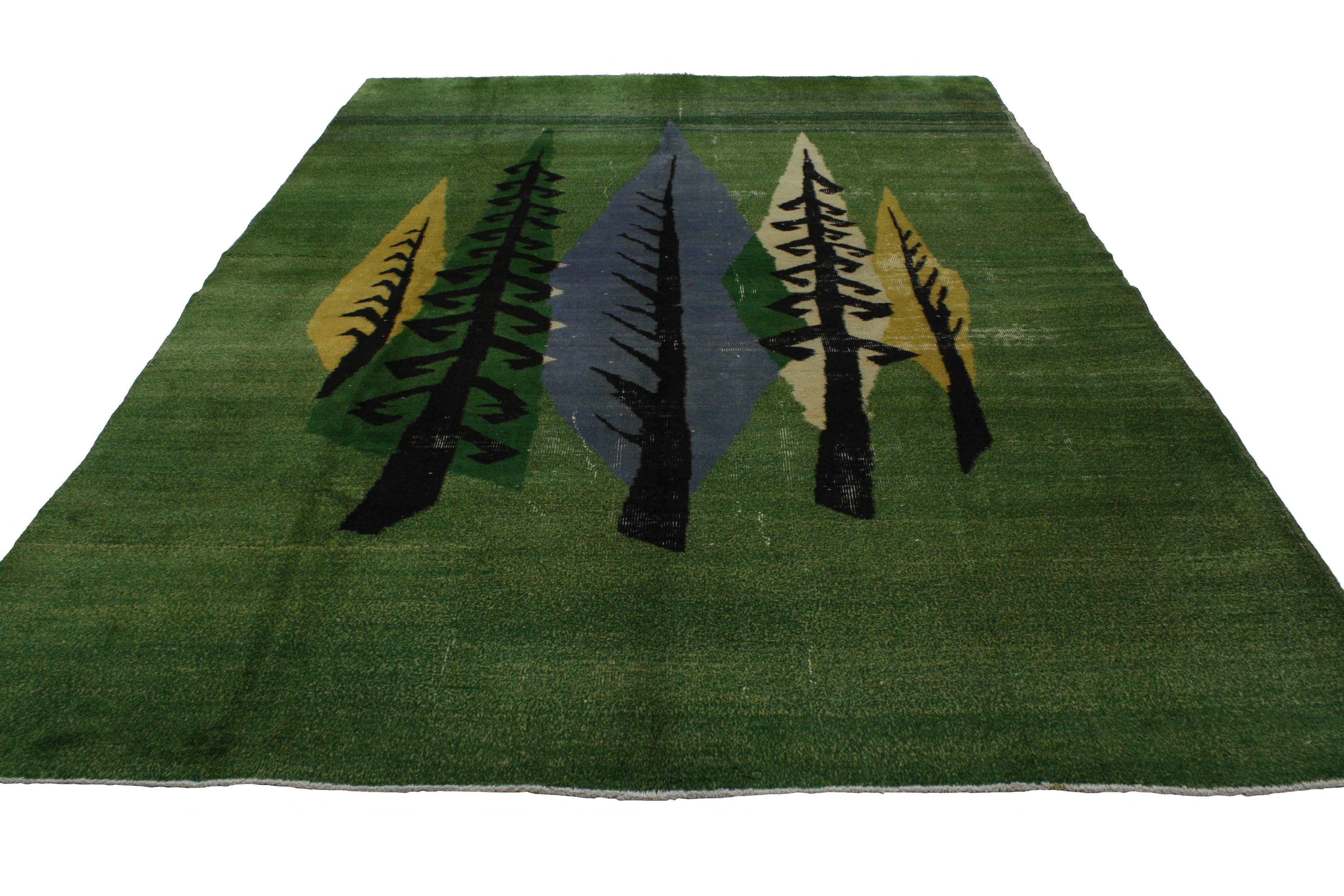 This distressed vintage Turkish Sivas rug with modern Industrial Art Deco style features a saturated green field with large-scale abstract trees. Attributed to the Turkish megastar, Zeki Müren, this Art Deco rug sports a simple yet effortlessly