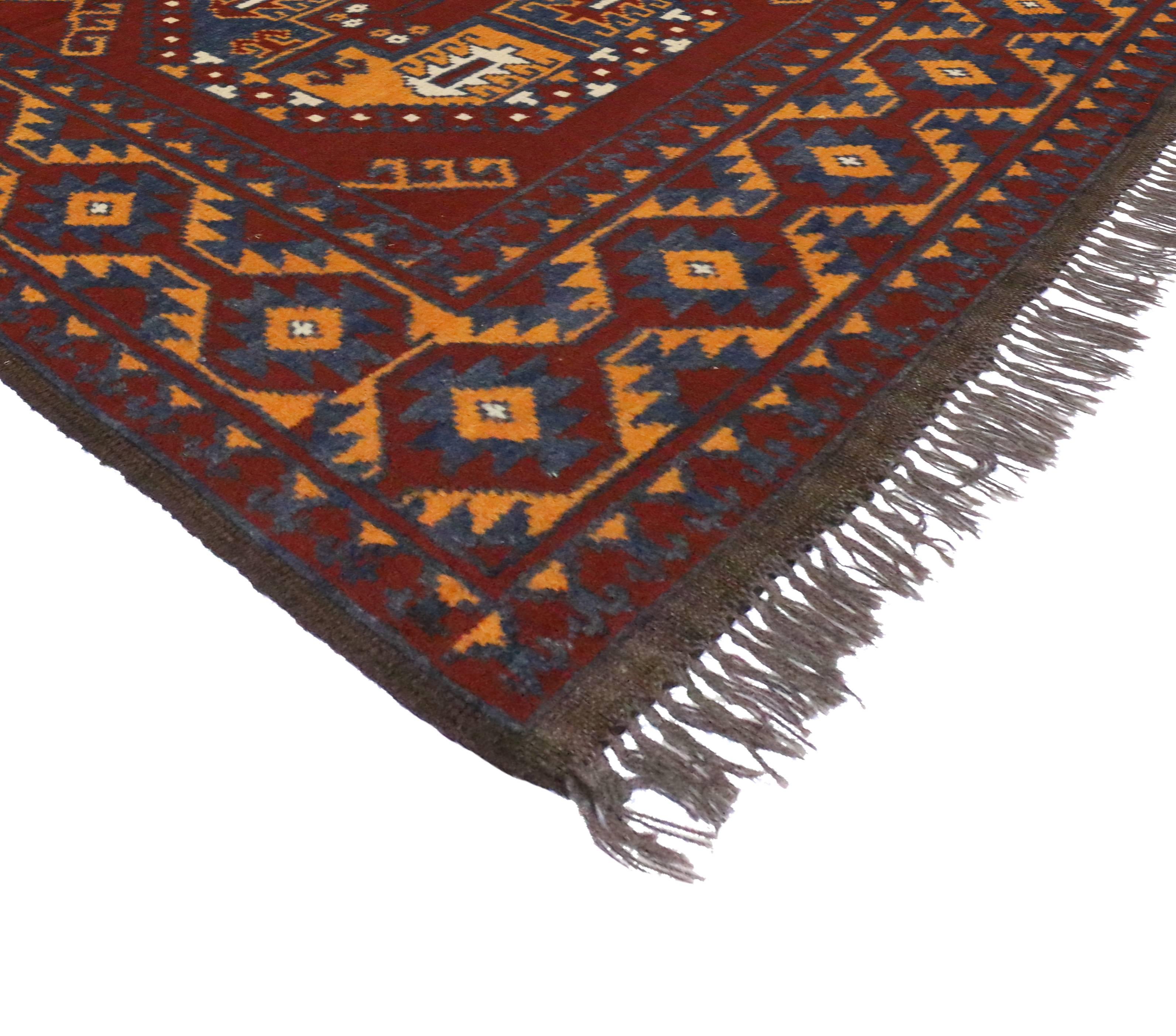 Bringen Sie eine moderne Atmosphäre in Ihren Raum mit diesem afghanischen Vintage-Teppich im modernen Tribal-Stil. Mit zwei großen geometrischen Medaillons und Stammesmotiven verkörpert dieser moderne Teppich echte Geradlinigkeit und zeichnet sich