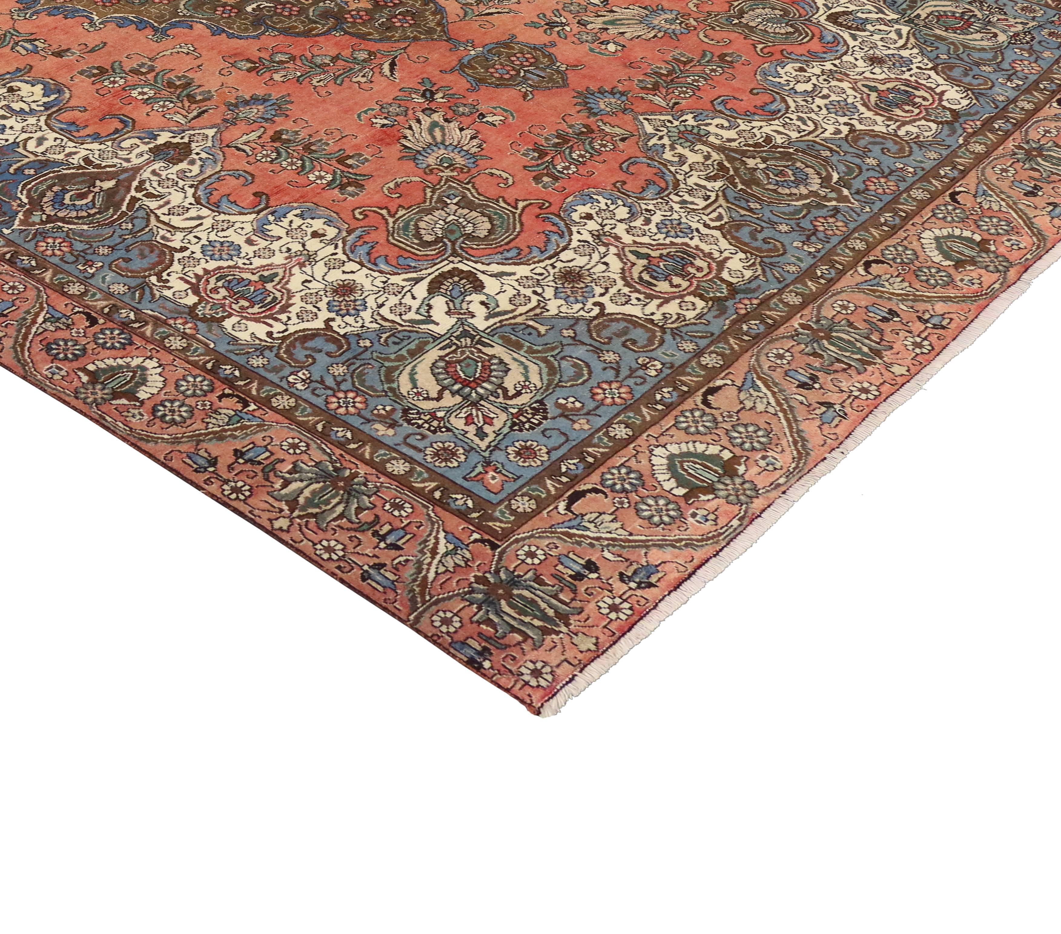 A beautifully detailed vintage Persian Tabriz rug boasts an intricate center medallion and elegant serenity blue spandrels with an impressive all-over pattern. The refined palette consists of Pantone's serenity blue, peach echo and iced coffee brown