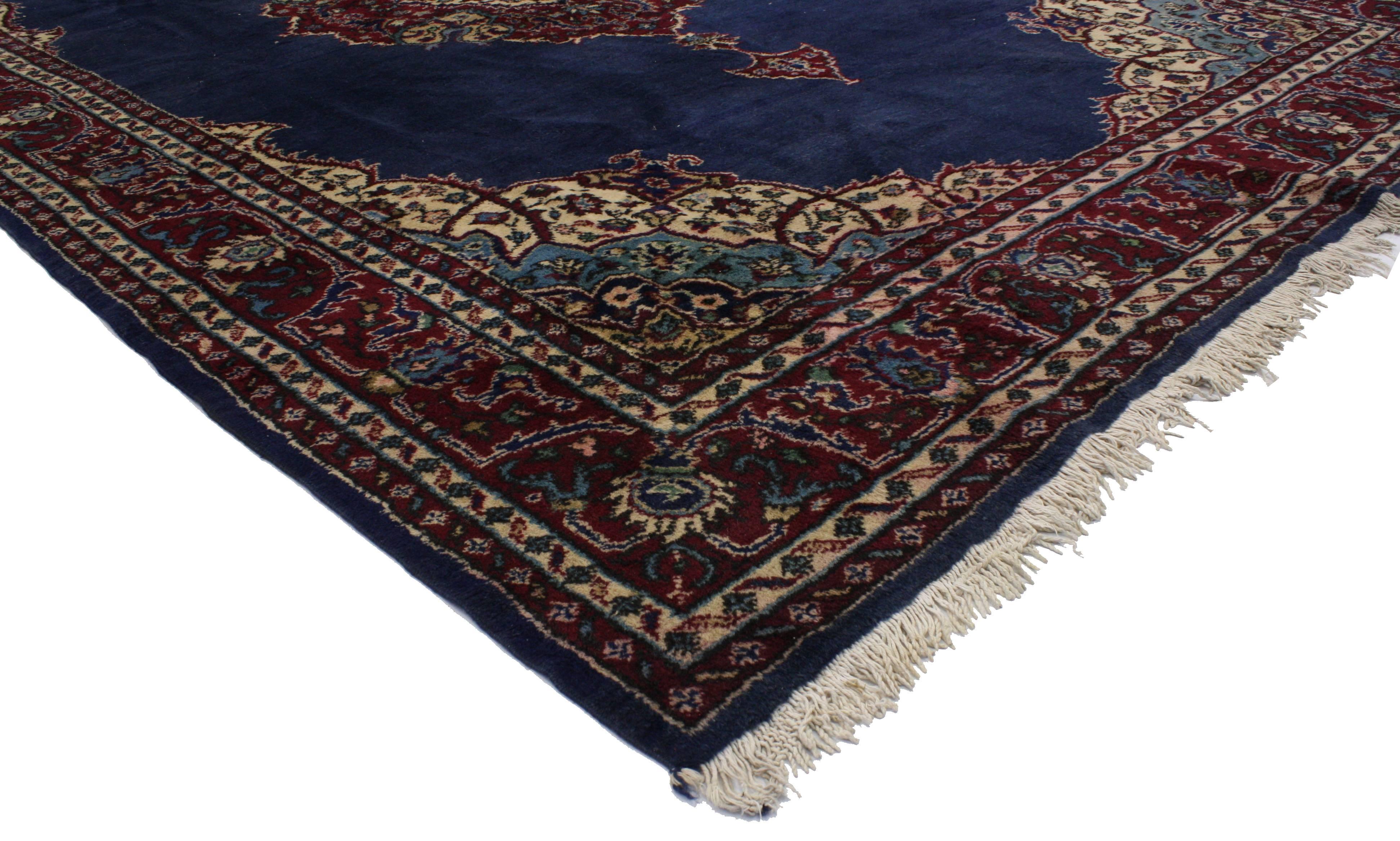 Hand-knotted wool antique Turkish Sparta rug with traditional modern style featuring an embellished center medallion in an open navy blue field surrounded by a geometric border and arabesque quarter panels. The color palette consists of navy blue,