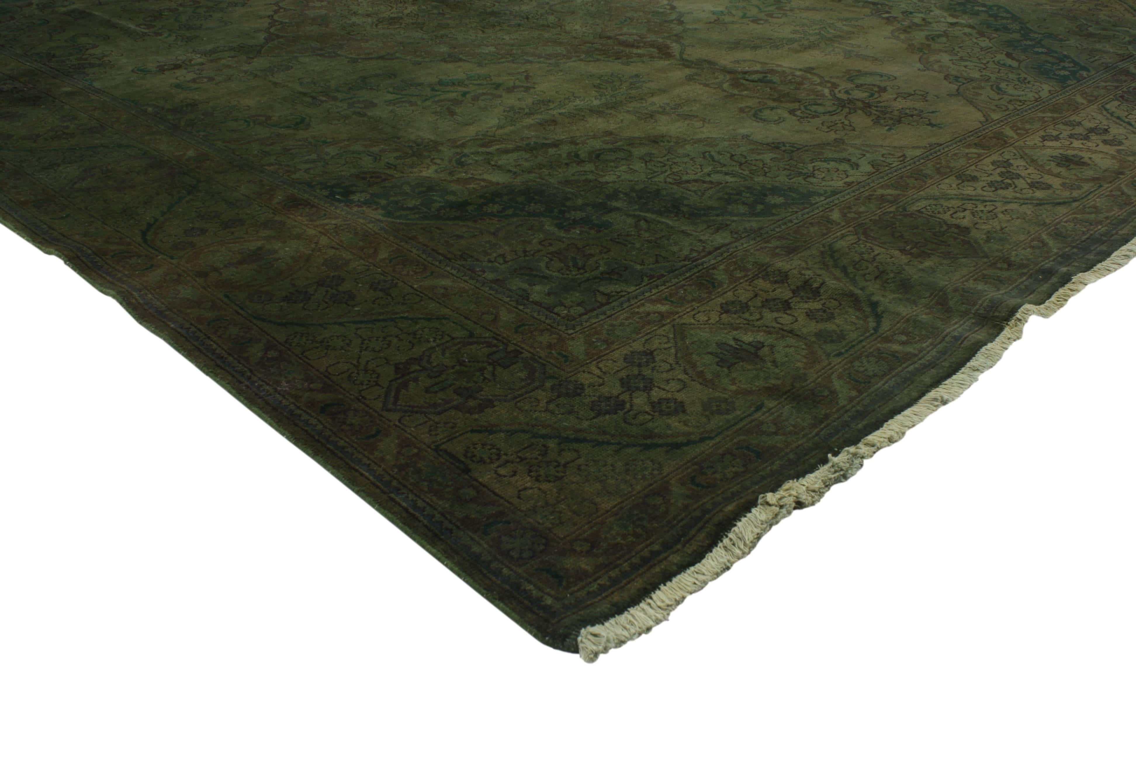 This modern style vintage Persian Tabriz overdyed green rug features an intricate diamond centre medallion surrounded by a complementary border. Saturated in green with variegated shades bring a refined presence when combined with its impeccable and